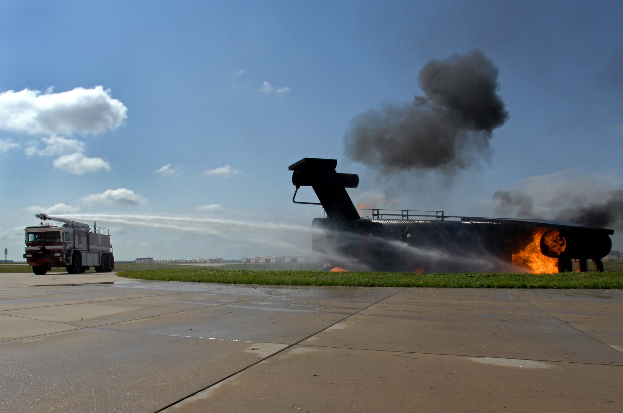WHITEMAN AIR FORCE BASE, Mo. - Firefighters with the 509th Civil Engineer Squadron use high-pressured hoses to extinguish a burning aircraft trainer during a live-burn exercise, Sept. 2. Enlisted and civilian firefighters battled hot flames for several hours during training in an effort to keep their qualification and skill up-to-date. The exercise is conducted once a year, and firefighters are put into several different scenarios where they are forced to react quickly and accurately. (U.S. Air Force photo/Senior Airman Kenny Holston)