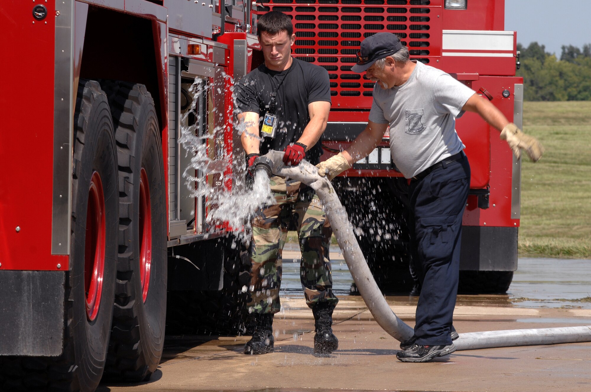 WHITEMAN AIR FORCE BASE, Mo. - Firefighters with the 509th Civil Engineer Squadron gain control of a fire hose during an aircraft live-burn exercise, Sept. 2. Several enlisted and civilian firefighters participated in the simulated aircraft fire to keep their qualifications and skills up-to-date. The exercise is conducted once a year, and firefighters are put into several different scenarios where they are forced to react quickly and accurately. (U.S. Air Force photo/Senior Airman Kenny Holston)