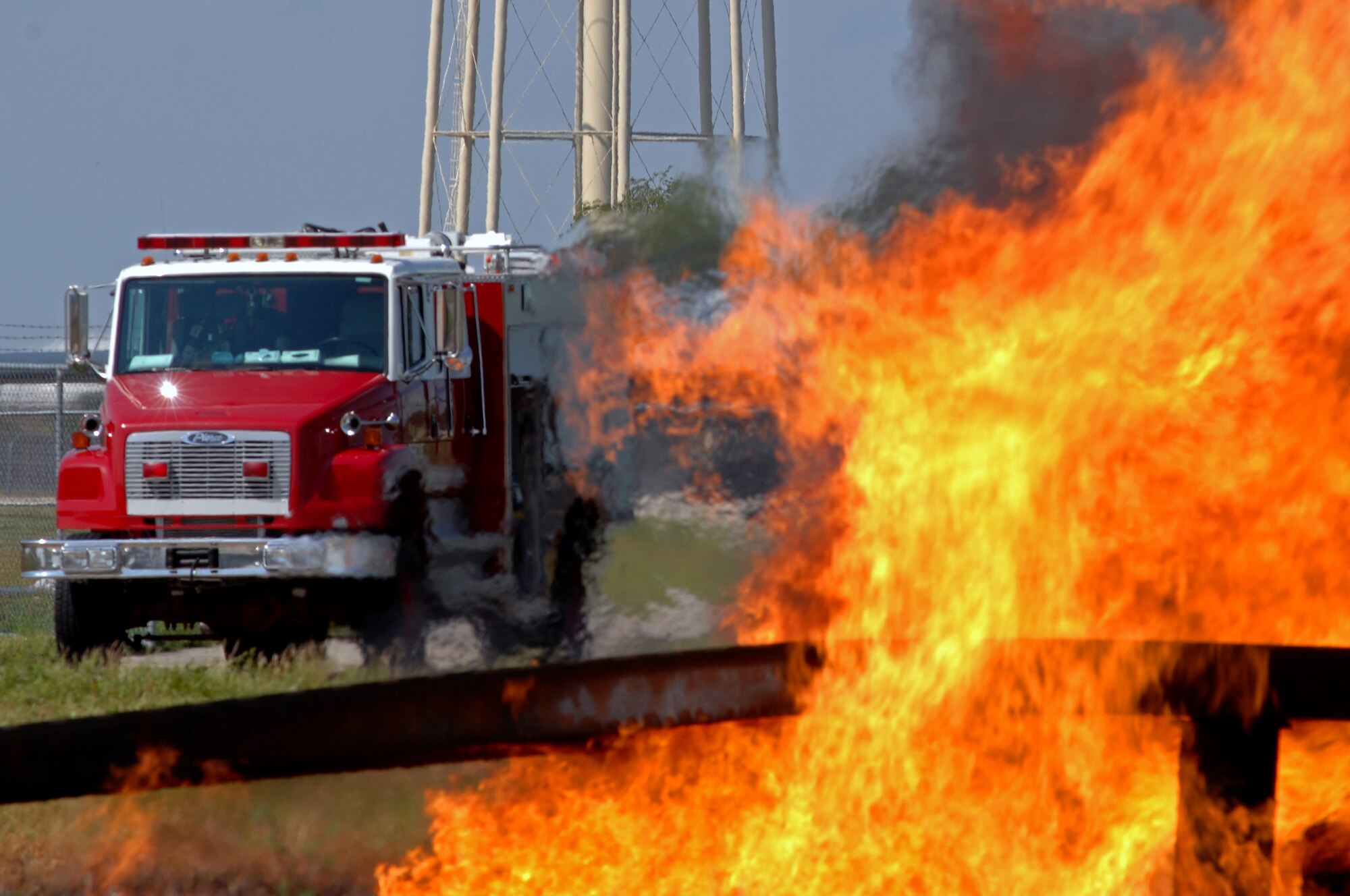 WHITEMAN AIR FORCE BASE, Mo. - Firefighters with the 509th Civil Engineer Squadron drive into position to fight a simulated aircraft fire during an aircraft live-burn exercise, Sept. 2. Several enlisted and civilian firefighters participated in the simulated aircraft fire to keep their qualifications and skills up-to-date. The exercise is conducted once a year, and firefighters are put into several different scenarios where they are forced to react quickly and accurately. (U.S. Air Force photo/Senior Airman Kenny Holston)