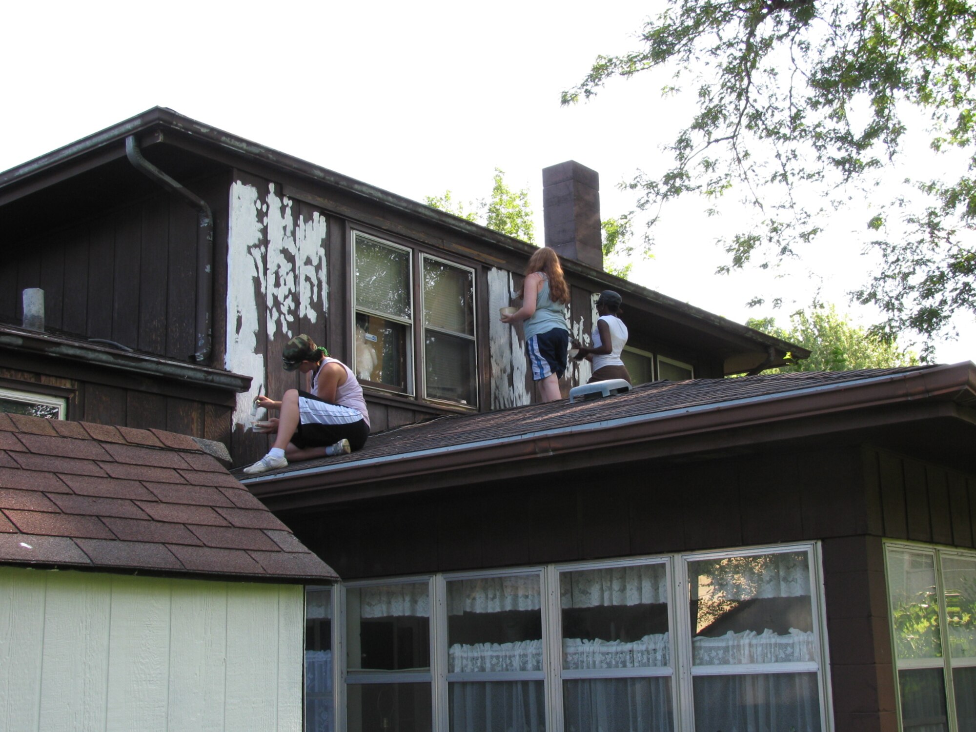 OFFUTT AIR FORCE BASE, Neb. -- Members of Team Offutt apply the first coat of paint to a house in Bellevue, Neb. Aug. 8 during the 21st annual Brush Up Nebraska Paint-A-Thon. The annual event started in Sept. 1989, since then more than 2,000 homes have been painted. U.S. Air Force Photo by Master Sgt. Kevin Pawlik 