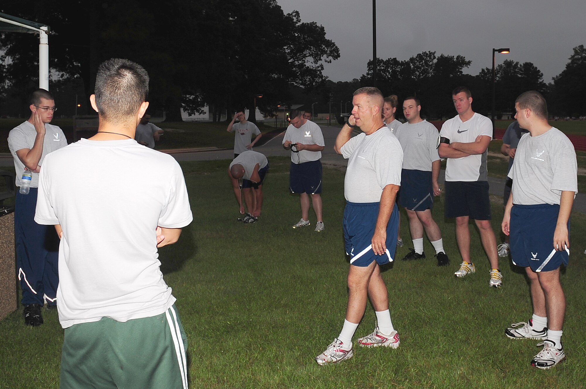 Master Sgt. David Fisher, (center) 4th Component Maintenance Squadron maintenance production analyst, demonstrates proper stretching techniques before the Timberwolf 5K challenge at the base fitness center on Seymour Johnson Air Force Base, N.C., August 24, 2009. Sergeant Fisher will run in the Air Force Marathon as a member of the Air Combat Command team. The marathon takes place September 19, 2009 at Wright Patterson Air Force Base, Ohio. The base running group Sergeant Fisher is a member of will also participate in the marathon. (U.S. Air Force photo by Airman 1st Class Rae Perry)