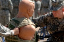 Trainees from Lackland's 326th Training Squadron demonstrate different hand to hand combat techniques on a dummy during combat skills training. Trainees are familiarized with combat maneuvers during BMT to better prepare them for future deployments. (U.S. Air Force photo/Senior Airman Nicole Roberts) 