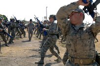 Tech. Sgt. Thomas Perry (center), a military training instructor from Lackland's 737th Training Support Squadron, critiques trainees from the 326th Training Squadron on different tactical positions during combat skills training. Trainees are familiarized with combat maneuvers during BMT to better prepare them for future deployments.  (U.S. Air Force photo/Senior Airman Nicole Roberts) 