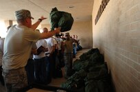 Trainees from Lackland's 321st Training Squadron move duffel bags for an incoming flight during a detail at clothing intial issue. Air Force Basic Military Training trainees perform details for many operations on base. (Air Force photo by Senior Airman Nicole Roberts)  