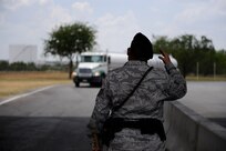 Tech. Sgt. Brian Amerault waves in a commercial truck to be inspected at Lackland's Growden Gate. The Growden gate is the commercial vehicle search area allowing trucks to enter Lackland. Sergeant Amerault is assigned to the 37th Security Forces Squadron. (U.S. Air Force photo/Staff Sgt. Desiree N. Palacios)