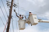 Staff Sgt. Johnny Blakely (left) and Staff Sgt. Jason Vargas, 37th Civil Engineer Squadron, reconnect a power line after it was knocked down on Lackland Air Force Base. (U.S. Air Force photo/Armando Flores)              