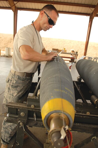 Staff Sgt. Gerald Taylor, 56th Equipment Maintenance Squadron conventional maintenance production manager, crimps arming wire on a MK-82, 500 pound general purpose bomb, at the munitions storage area at Luke AFB, Aug. 31. This 500 pound live explosive's fuse is set for 6 seconds upon impact and covers 4,000 feet.  (U.S. Air Force photo by Airman 1st Class Ronifel Yasay)