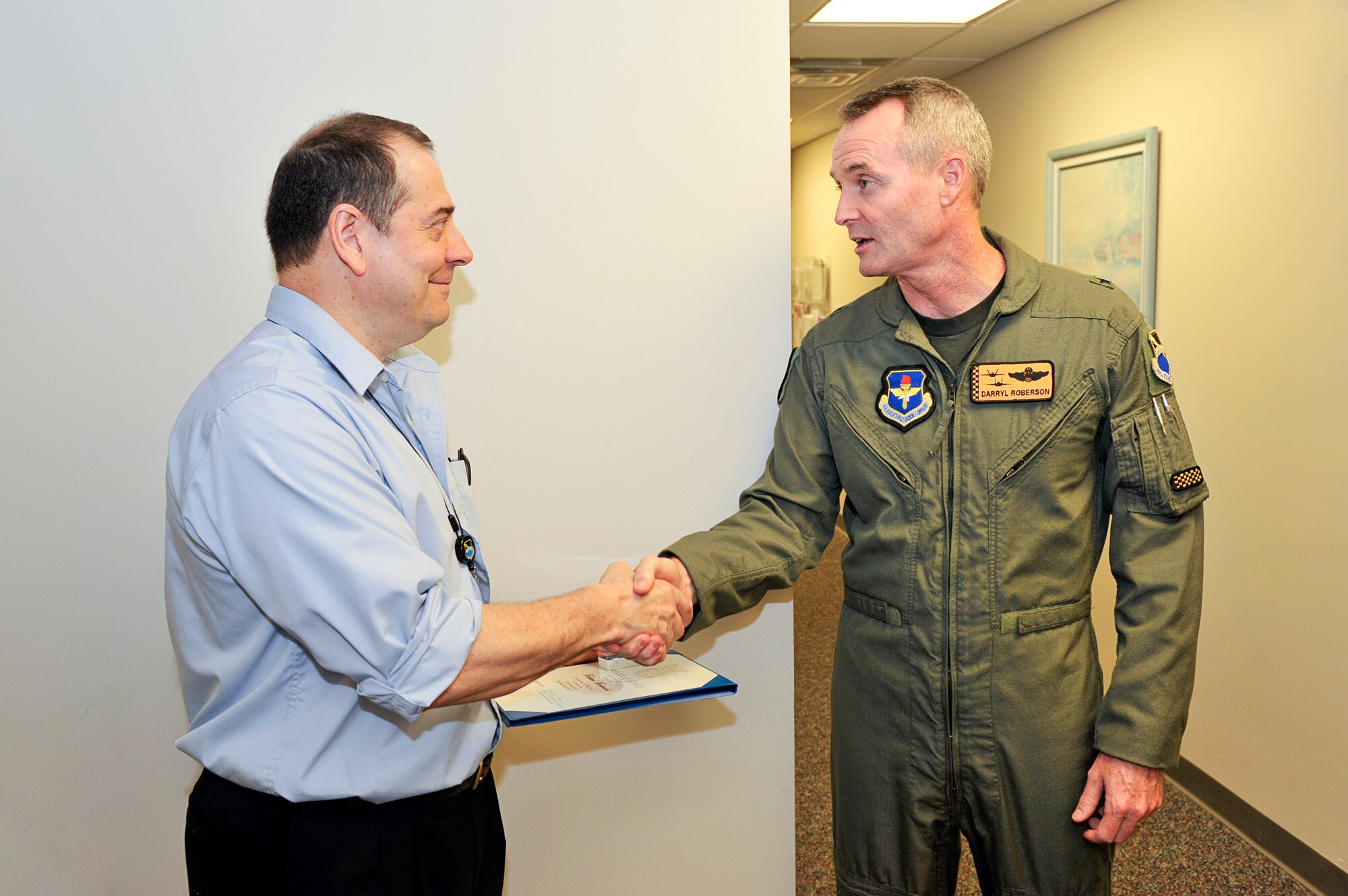 Brig. Gen. Darryl Roberson, 325th Fighter Wing commander, congratulates Richard Martincich, 325th Medical Support Squadron release of information clerk, for his 30 years in Civil Service with a pin and certificate here Sept. 2. (U.S. Air Force photo/Jonathan Gibson)