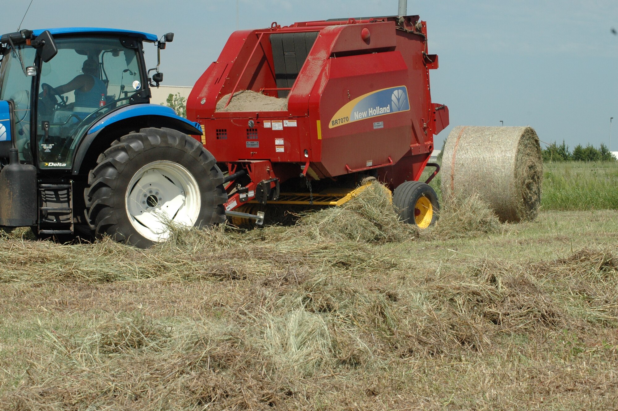 Under a new five-year lease agreement, a local farmer nears completion of haying operations at the Tinker Aerospace Complex. “The 115 acres will be hayed up to twice a year,” said John Krupovage, Tinker’s Natural Resource manager. “The operation so far has yielded a harvest of over 300 large round bales.”  “We hay late [after July 15] to comply with the Migratory Bird Treaty Act - migratory birds such as meadowlarks, dickcissels and other birds nesting these grassy areas,” he said. Additionally, instead of being mowed at our expense, the base makes a little money on the lease and the hay is used to feed livestock. Officials with 72nd Civil Engineering are committed to finding ways to maintain Tinker Aerospace Complex at no additional cost. (Air Force photo by Brion Ockenfells)