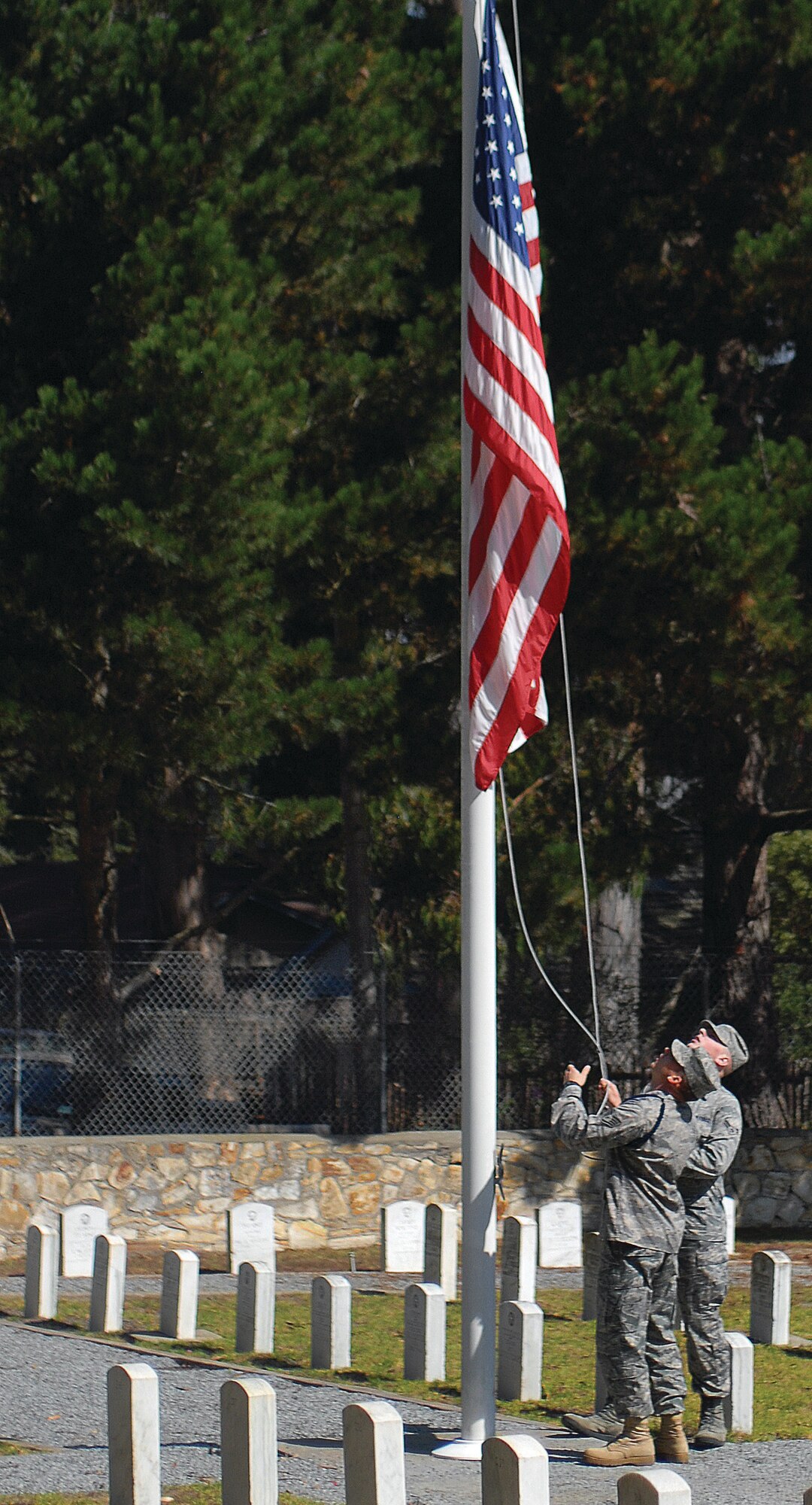 Staff Sgt. Damian Davies and Airman 1st Class Matthew Jenner, 314th and 311th Training Squadrons respectively, lower the American flag to half-staff at the Presidio of Monterey Military Cemetery in honor of Massachusetts’s Senator Edward M. Kennedy. Kennedy died on Aug. 25 due to brain cancer. He was 77. (U.S. Navy photo by Petty Officer 2nd Class Steven L. Shepard).