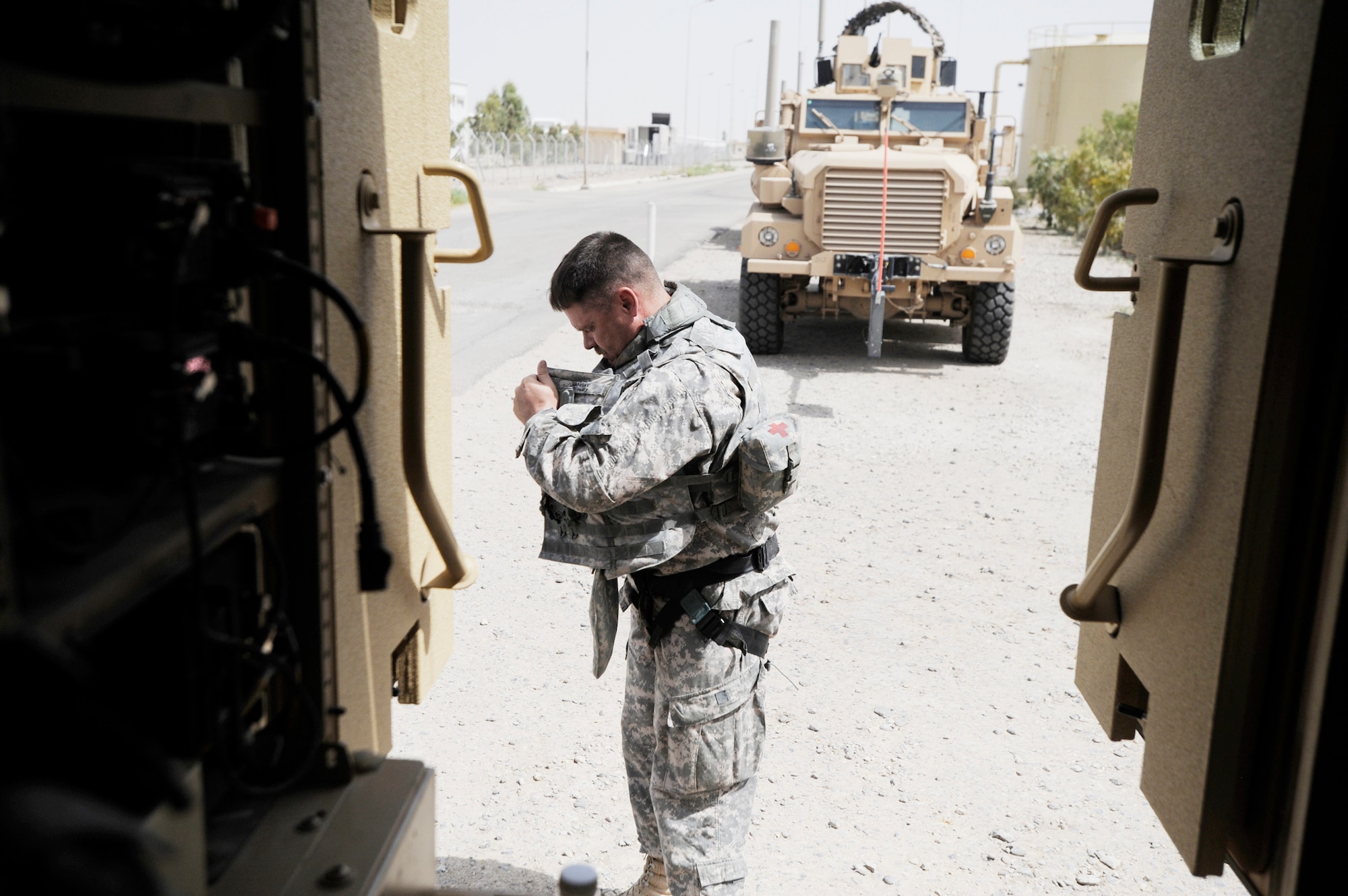 Lt. Col. Steven Ramsay dons a harness in preparation for a convoy to Contingency Operating Base Adder, Iraq, from Camp Ur, an Iraqi military base Aug. 17, 2009. Colonel Ramsay, deployed from Keesler Air Force Base, Miss., and his team advise their Iraqi military counterparts on base operations. Colonel Ramsay is the Logistics Military Advisory Team senior adviser. (U.S. Air Force photo/Staff Sgt. Shawn Weismiller) 