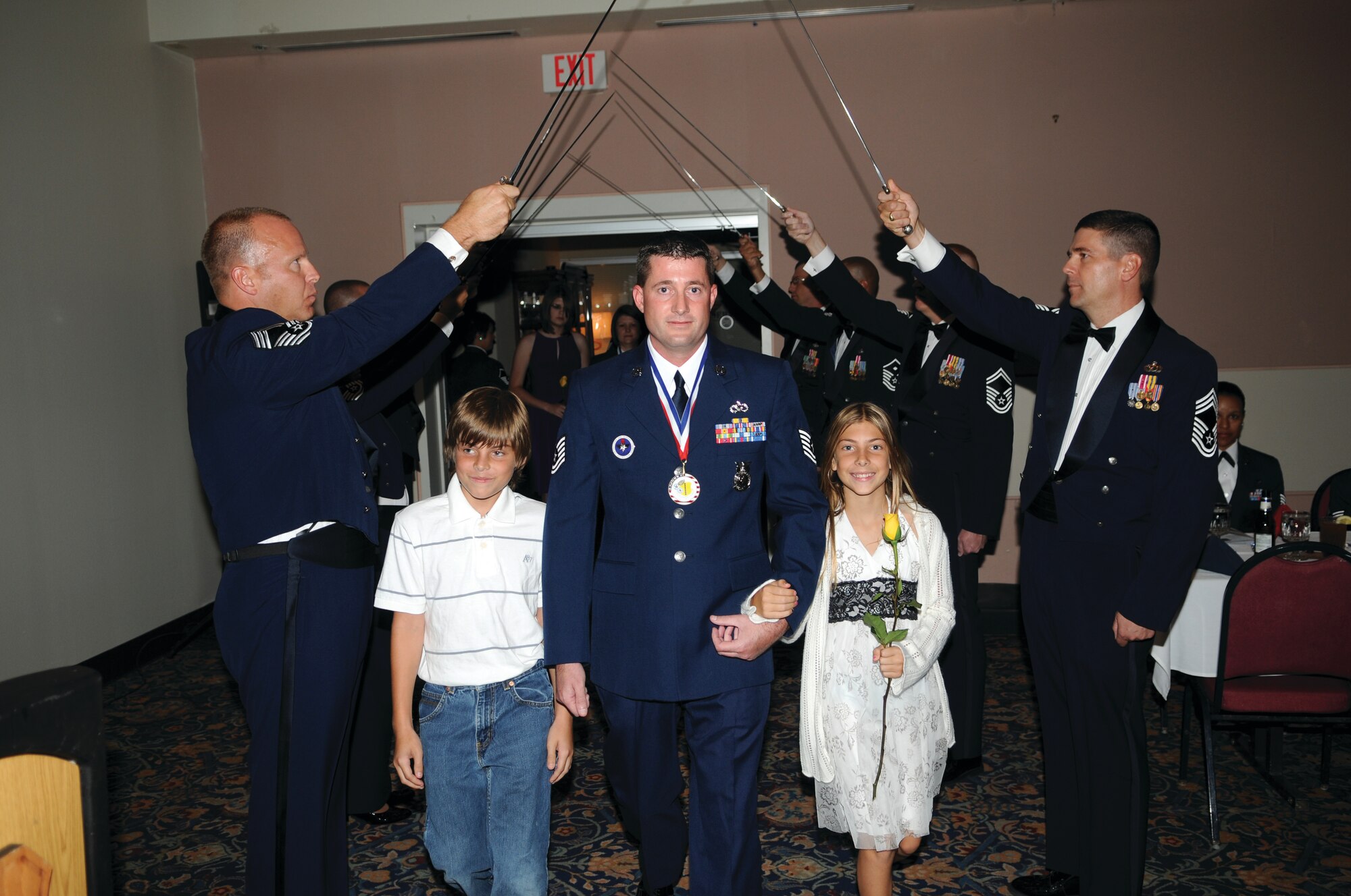 Master Sgt. Terry J. Dybdahl, 312th Training Squadron, his son Hayden and daughter Logan make an entrance through a Saber Team Cordon at the Goodfellow Senior Noncommissioned Officer Induction Ceremony at the Event Center, Aug. 27. (U.S. Air Force photo by Tech. Sgt. John Barton). 