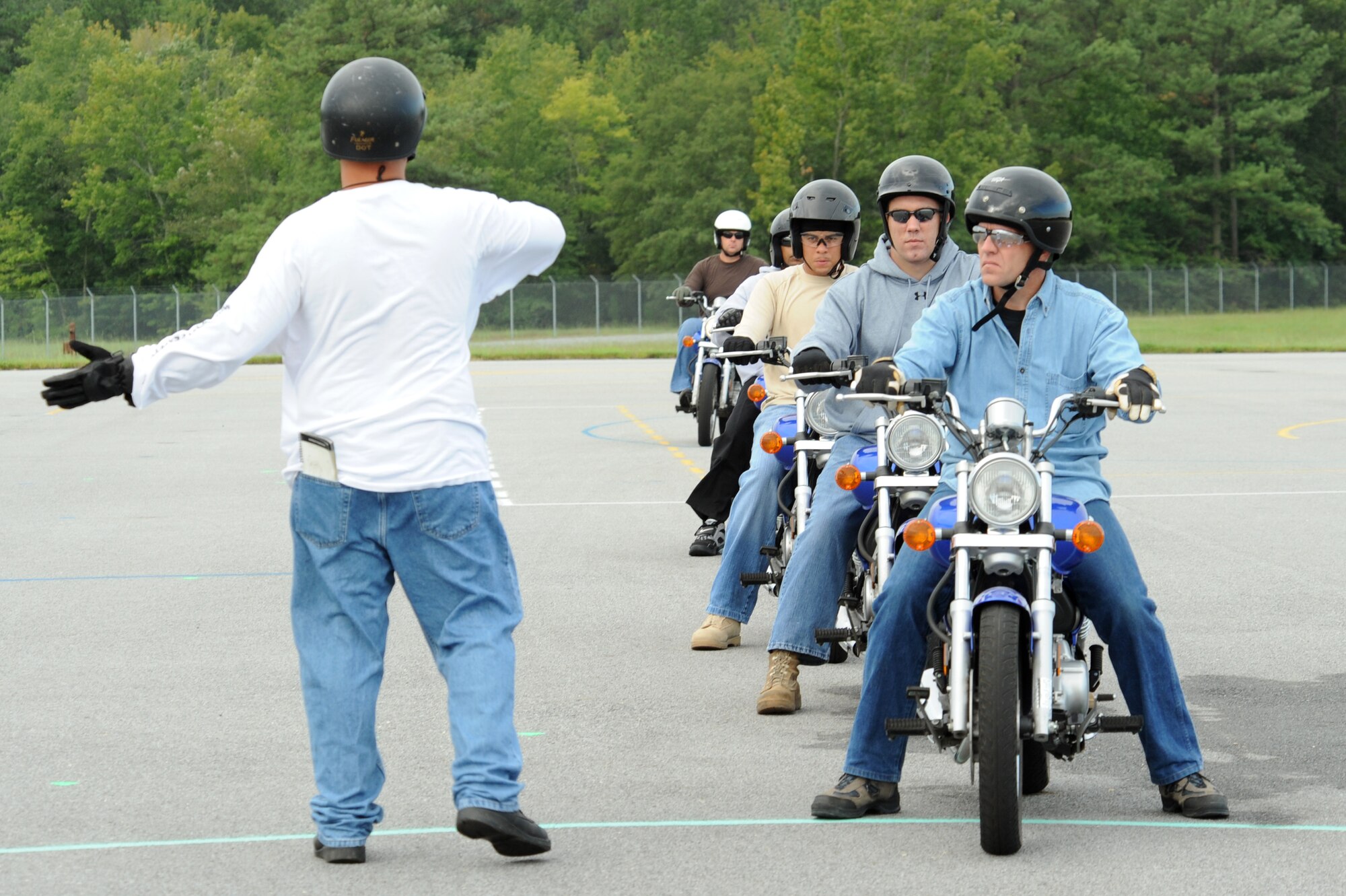 Senior Master Sgt. John Sarmento, 4th Fighter Wing motorcycle safety program manager, signals Tech. Sgt. Steven Beckett, 4th Civil Engineer Squadron firefighter, to fall in line during the Basic Rider's Course on Seymour Johnson Air Force Base, N.C., Sept. 1, 2009. Sergeant Sarmento has taught this course for a year and a half. (U.S. Air Force photo by Airman 1st Class Whitney Lambert)