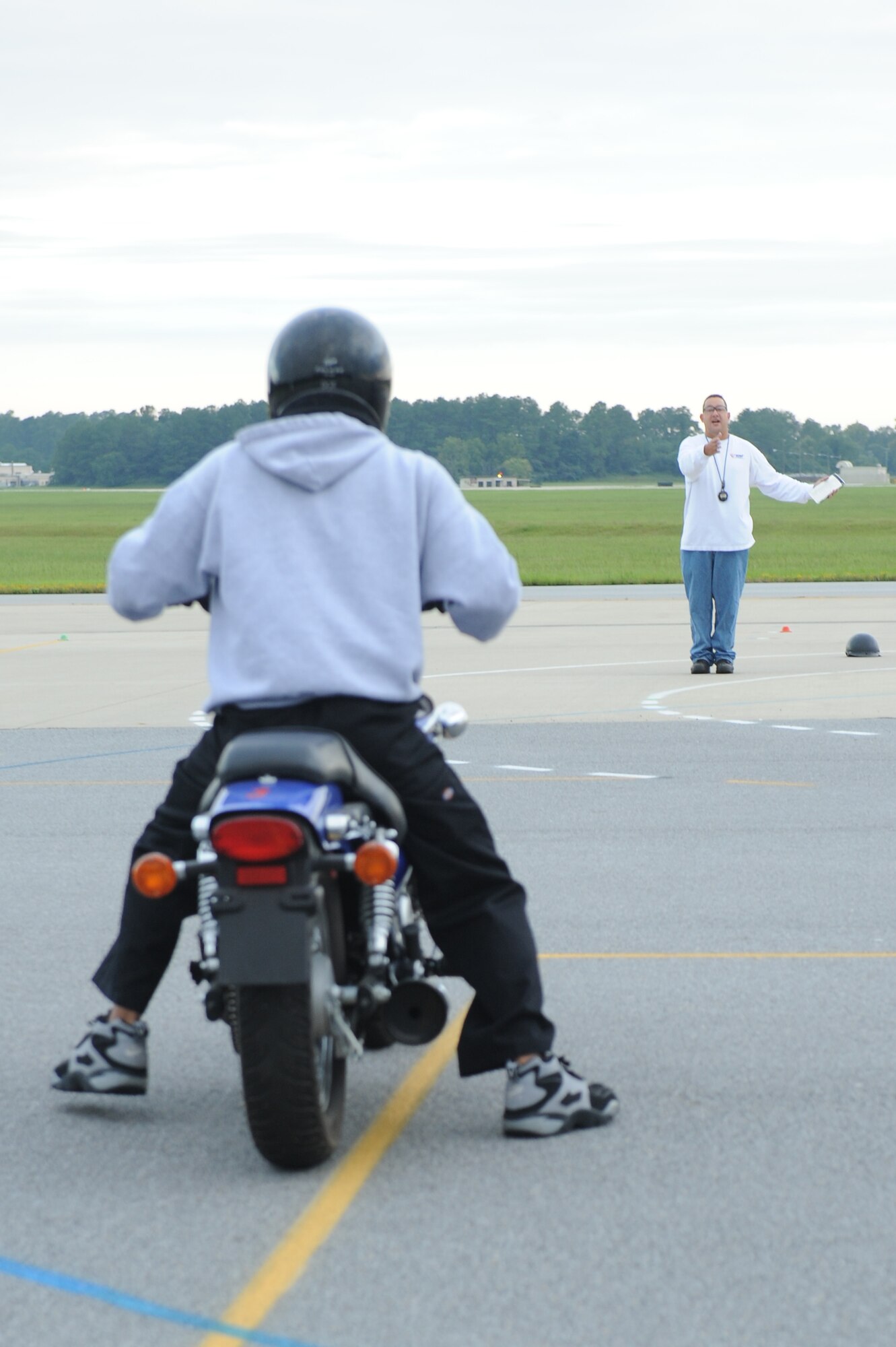 Senior Master Sgt. John Sarmento, 4th Fighter Wing motorcycle safety program manager, signals Airman 1st Class Brian Delacruz, 4th Force Support Squadron food service apprentice, during the basic rider's course on Seymour Johnson Air Force Base, N.C., Sept. 1, 2009. Since October 2008 more than 157 members of Team Seymour have taken this course.(U.S. Air Force photo by Airman 1st Class Whitney Lambert)