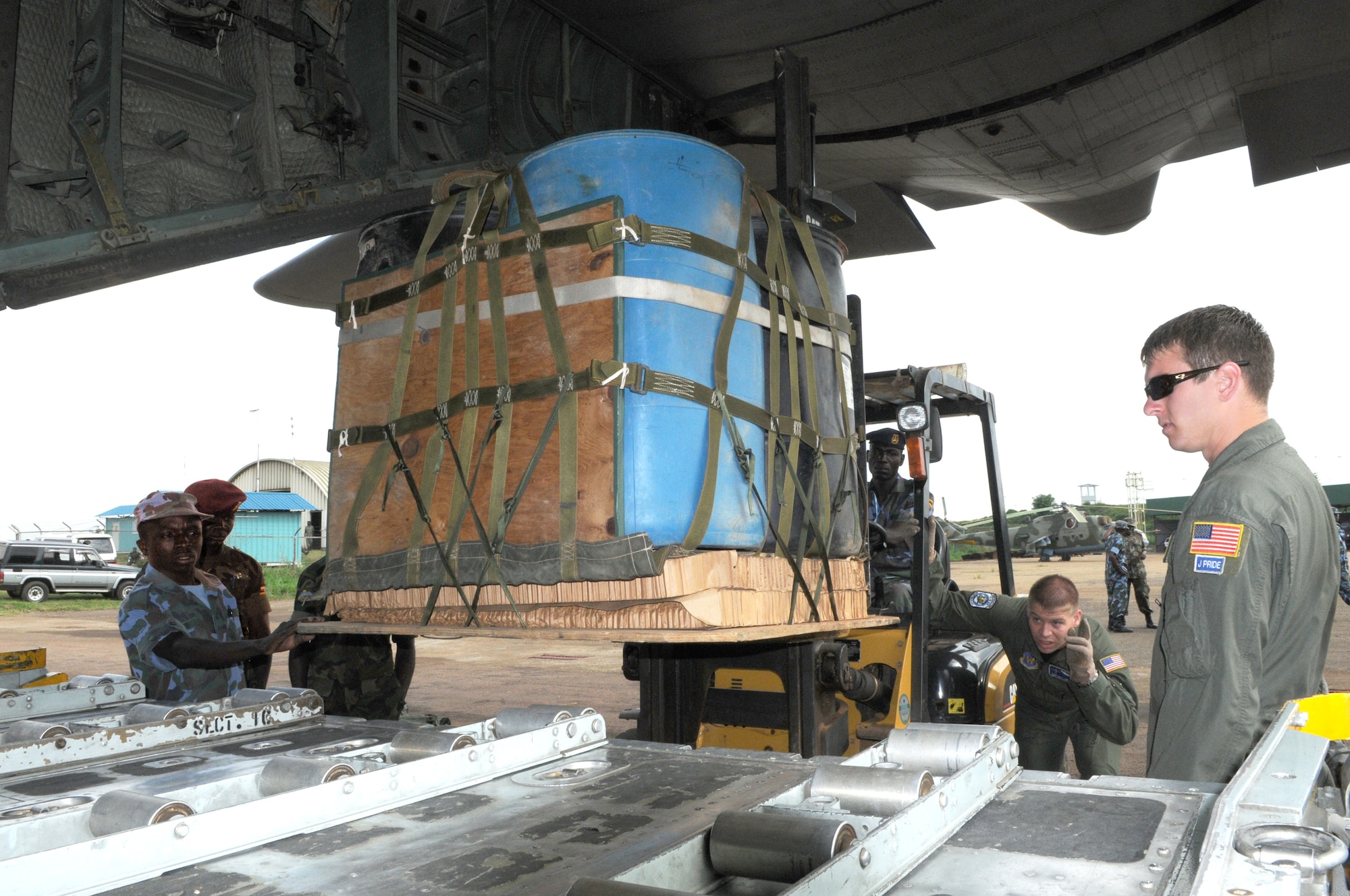 Staff Sgt. Brock Knobloch directs the forklift operator as U.S. and Ugandan troops position an airdrop pallet on a C-130 Hercules Aug. 28 during a theater security cooperation event at Entebbe Air Base, Uganda. (USAF photo by Maj. Paula Kurtz) 