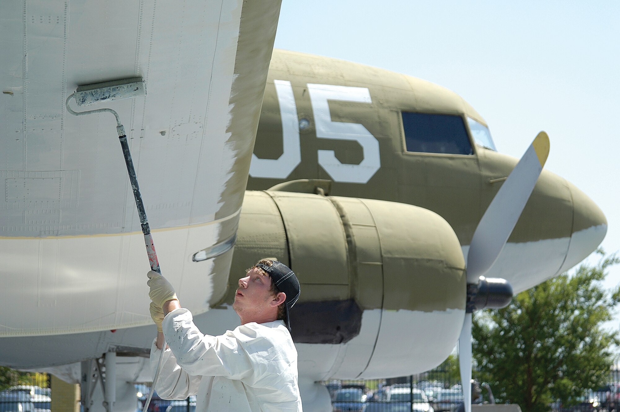 Mike Phillips, of Sooner Coating, paints the underside of the C-47 “Skytrain” or “Gooney Bird.” When work began last week to repaint all the aircraft at the Charles B. Hall Airpark here, the C-47 was the first project and will be followed by the A-7 and the B-29 to finish 2009. The Gooney Bird was made from 1943-45 by Douglas Aircraft with more than half of the 10,000 planes rolling out from what is now known as Bldg. 3001. The aircraft took part in the invasion of Normandy, and the 65th anniversary of the end of the invasion was Aug. 25. (Air Force  photo by Margo Wright)