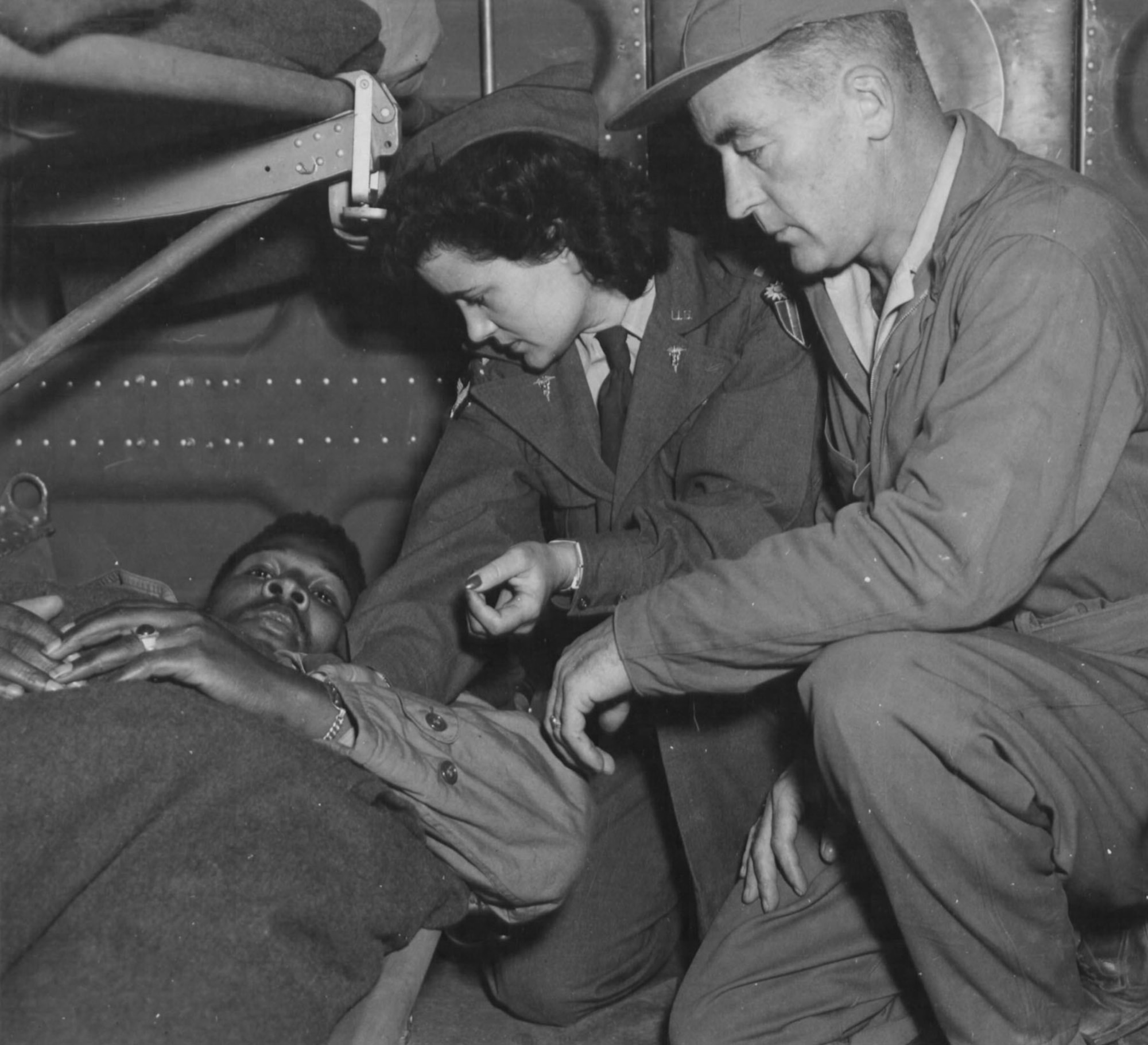 A C-47 air evacuation team from the 803rd Air Evacuation Transportation Squadron, Lt. Pauline Curry and Tech. Sgt. Lewis Marker, check a patient on a flight over India. (U.S. Air Force photo)
