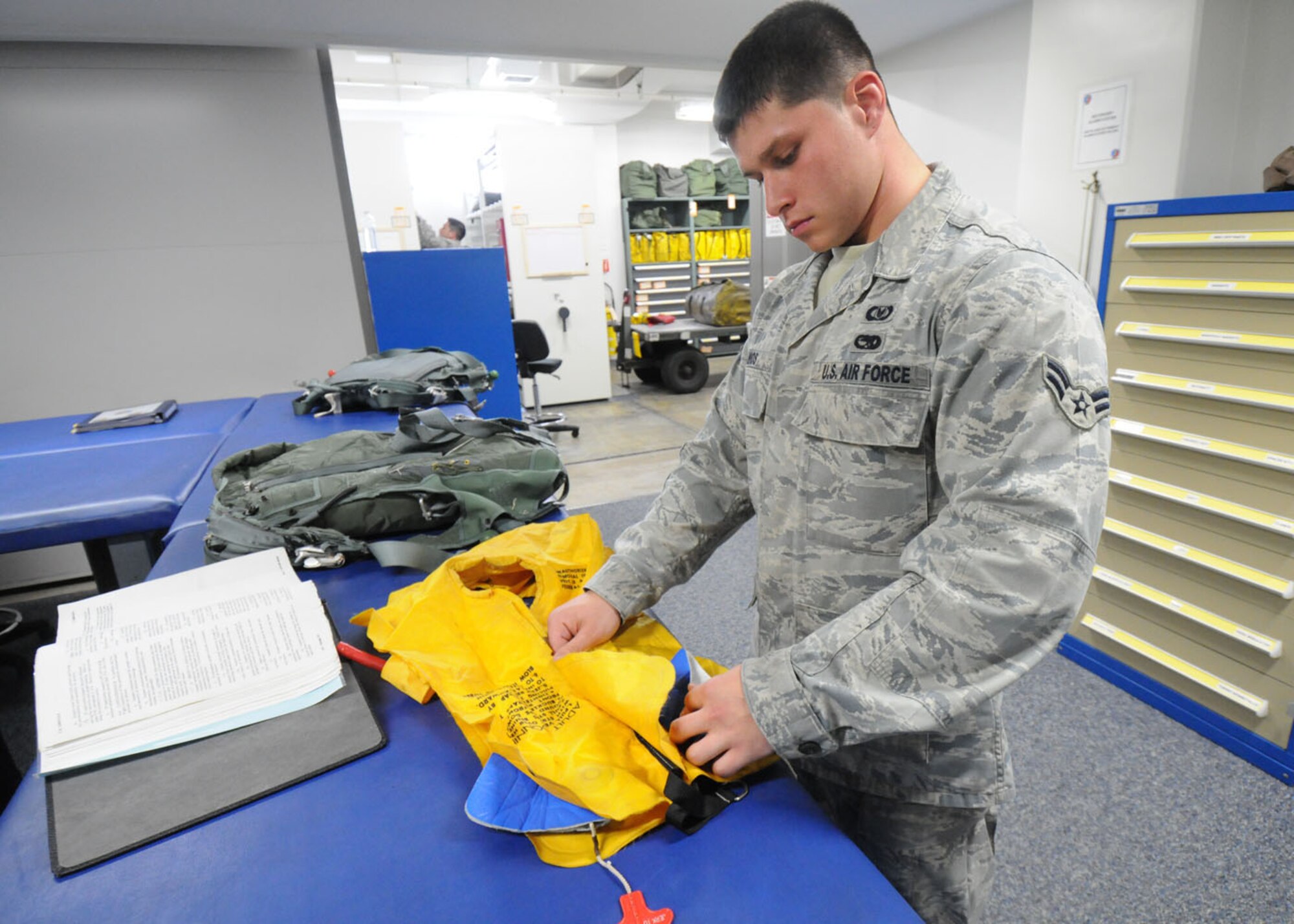 YOKOTA AIR BASE, Japan -- Airman 1st Class Matthew Ramos, 374th Operations Support Squadron aircrew flight equipment apprentice, uses technical orders to follow step-by-step directions on how to inspect a life preserver Sept. 2. Aircrew flight equipment  technicians ensure life-saving survival equipment used by aircrew members is properly functioning by inspecting and maintaining items such as flight helmets, oxygen masks, parachutes, flotation devices, survival kits, helmet mounted devices, aircrew night vision and other ocular systems. They also check anti-gravity garments, aircrew eye and respiratory protective equipment, chemical biological protective oxygen masks and coveralls, and other types of aircrew flight equipment and aircrew chemical defense systems. (U.S. Air Force photo/Staff Sgt. Veronica Pierce)