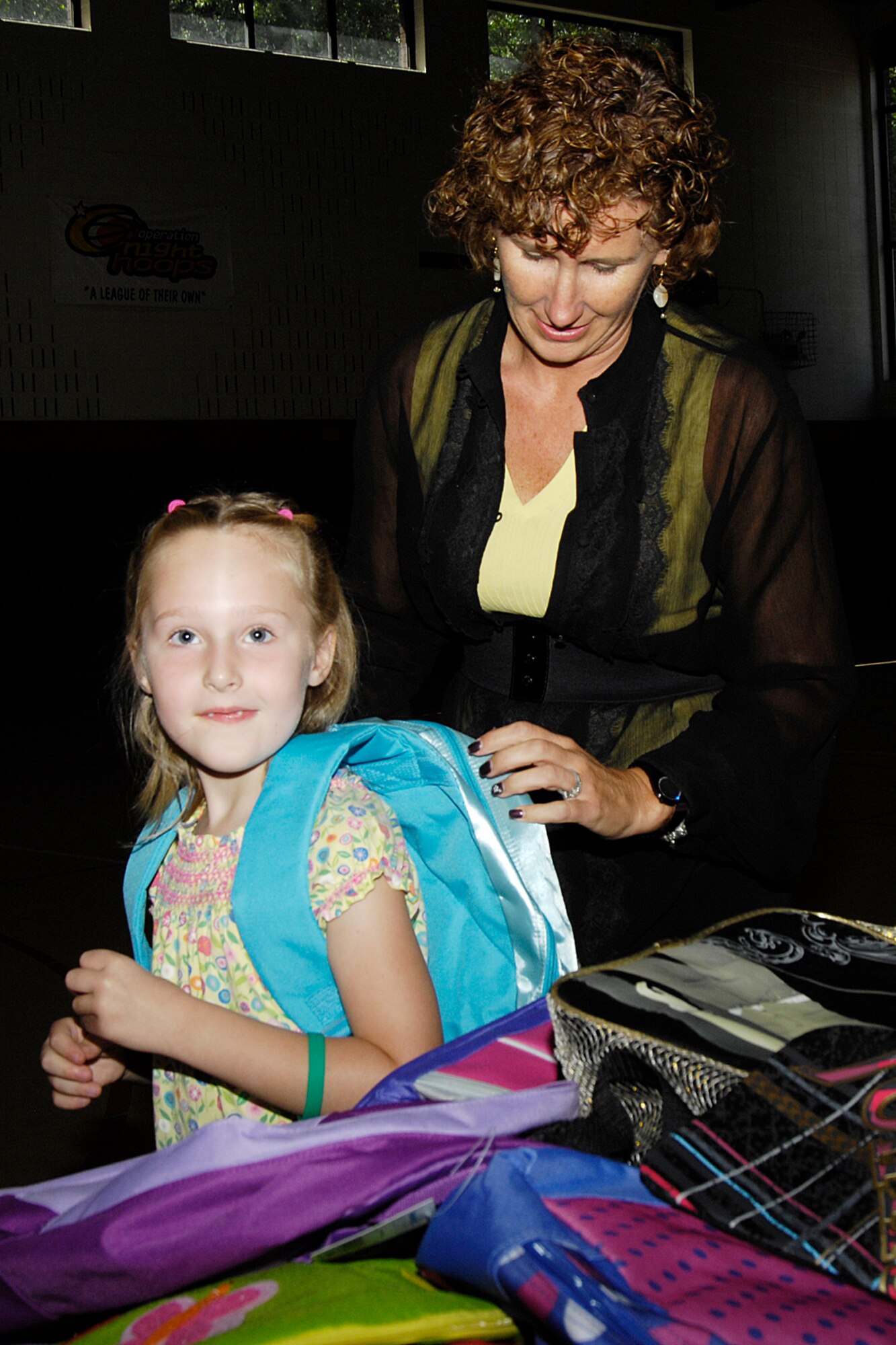 HANSCOM AIR FORCE BASE, Mass. –Karen Laskowsky, an Operation Homefront
Volunteer helps a Hanscom student try on a backpack during the Operation Homefront backpack giveaway at the Youth Center on Sept. 1. Operation Homefront donated school supplies and backpacks to military children in grades kindergarten through high school. (U.S. Air Force photo by Linda LaBonte Britt)
