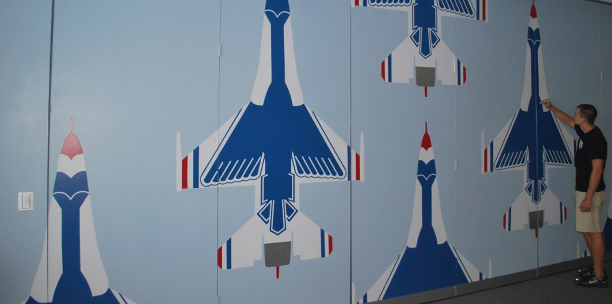 Cadet Tyler Holley, of the University of Florida's Air Force ROTC detachment, adds the final touches on the detachment 150's wall mural of the U.S.A.F. Thunderbirds in flight. The mural measuring 11-feet high by 24-feet wide took an eight-person cadet and cadre team three weeks to complete. (Courtesy photo)
