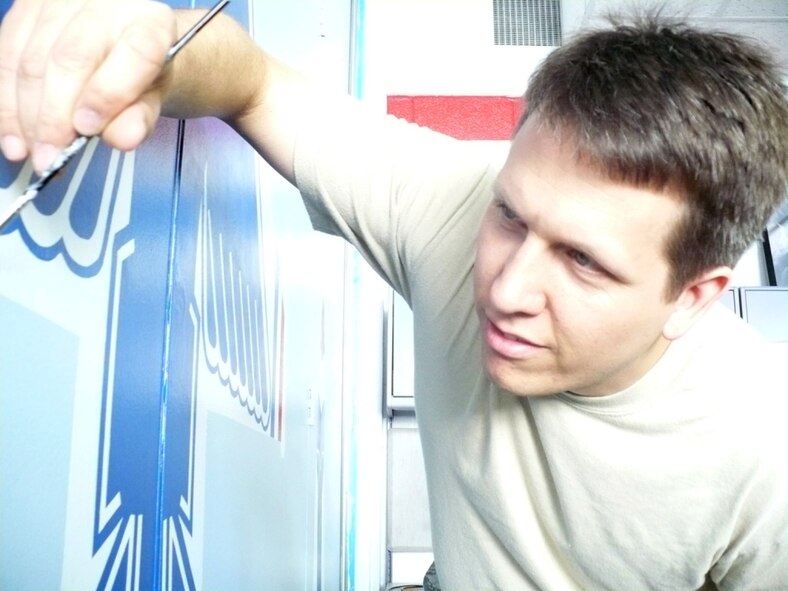 Maj. Jim Bodnar, University of Florida Air Force ROTC detachment 150 unit admissions officer, adds the finishing touches to the detachment's U.S.A.F. Thunderbirds wall mural. (Courtesy photo)