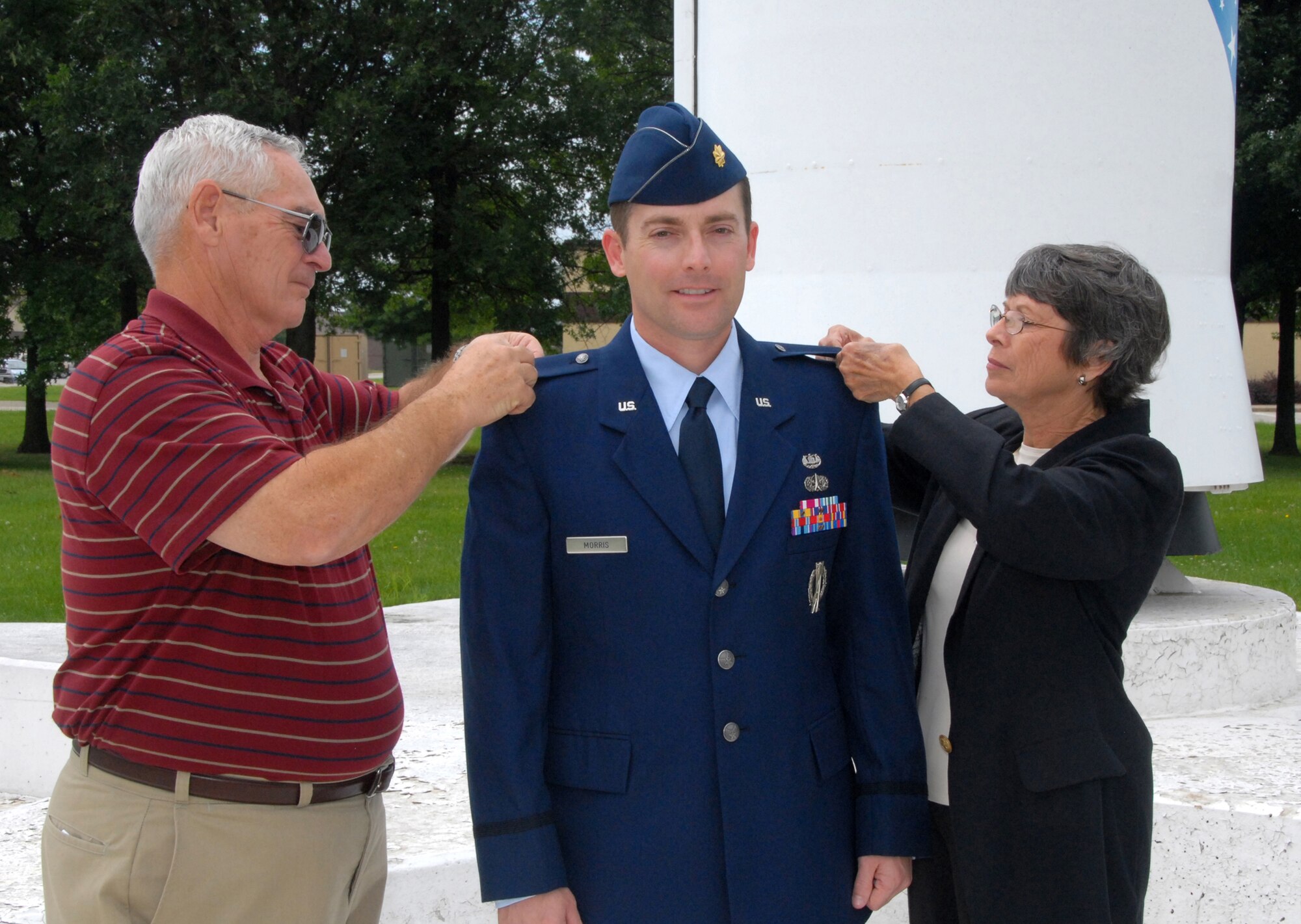 Lt. Col. Jeff Morris, 442nd Fighter Wing staff judge advocate, stands in front of a Minuteman II missile on static display at Whiteman Air Force Base, Mo., Aug. 1, as his parents, Calvin and Margie Morris, pin on his lieutenant colonel insignia to mark his recent promotion.  The Minuteman missile has special significance for Colonel Morris and his father.  Colonel Morris is a former Minuteman II missile-launch officer, while his father served at Whiteman from 1963 to 1965 guarding Minuteman missiles in what was then called the Air Police, now known as Security Forces.  The 442nd Fighter Wing is an Air Force Reserve Command unit based at Whiteman, which flies the A-10 Thunderbolt II. (U.S. Air Force photo/Maj. David Kurle)  