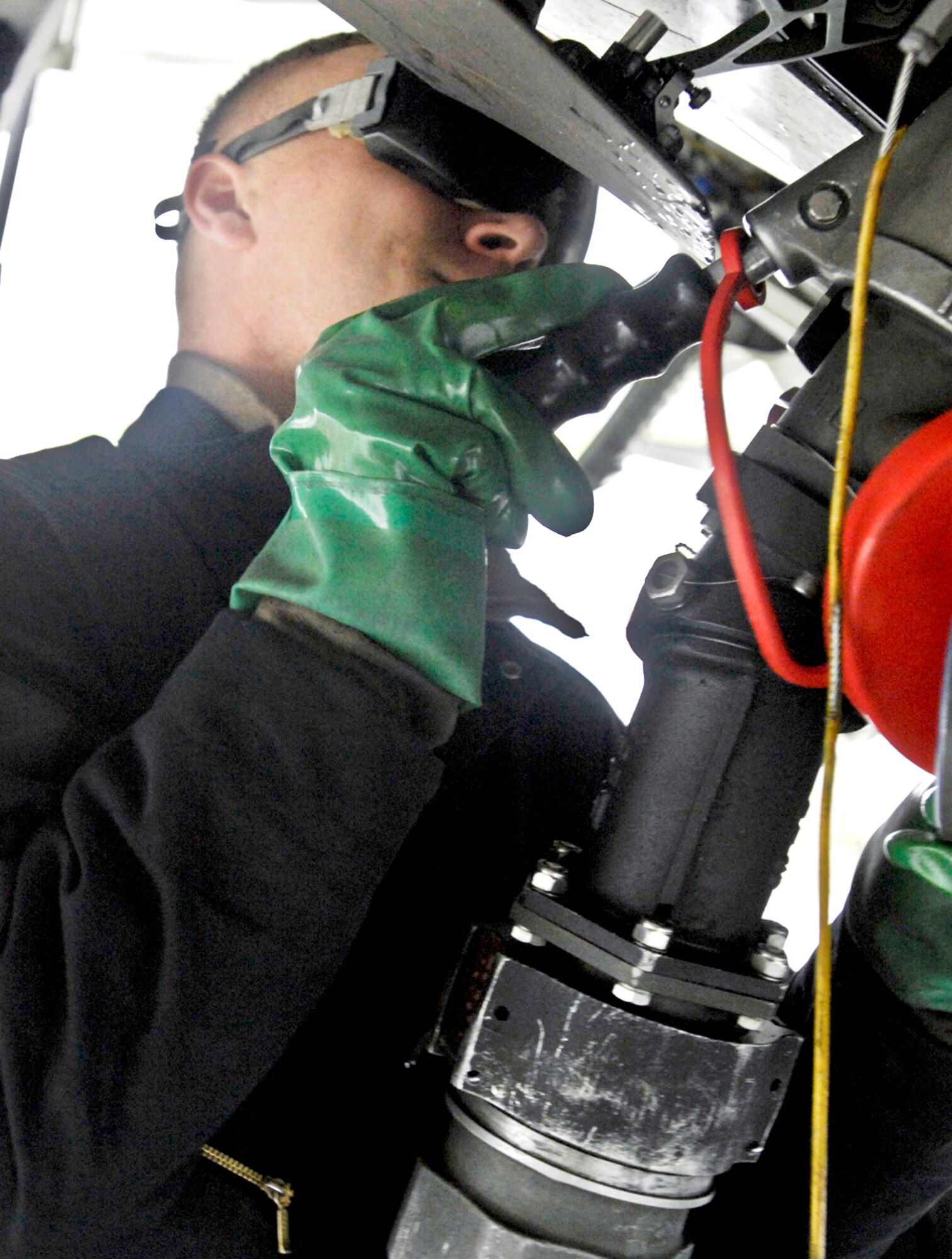 Airman 1st Class Alexander Chisholm hooks up a fuel hose to an F-22 Raptor Sept. 1, 2009, at Elmendorf Air Force Base, Alaska. Base members began using Plus 100 additive in their JP-8 aviation fuel Sept. 1. The additive helps prevent buildup in F-15 Eagle and F-22 Raptor engines; therefore it will reduce the amount of maintenance needed on those engines. Airman Chisholm is assigned to the 525th Aircraft Maintenance Unit. (U.S. Air Force photo/Airman 1st Class Christopher Gross)