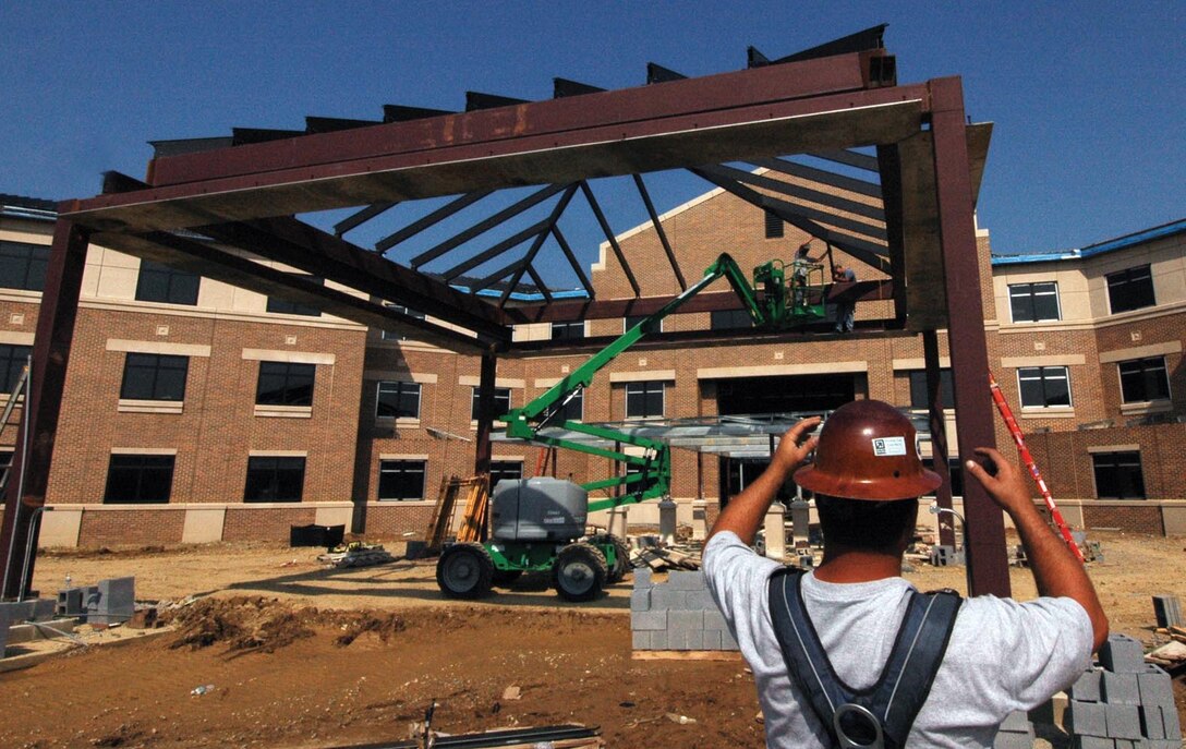 Gary Rabon, a job foreman contractor,  gives guidance to his worker as he installs a steel joyce on to the  port cochure, at the front entrance of the new Gateway Inn Aug. 24.  The three-story facility will have 265 rooms and is tentatively scheduled for completion January 2010. (U.S. Air Force photo/ Bobby Jones)