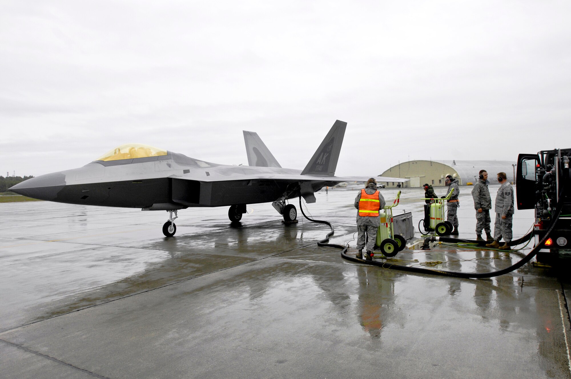 Members of the 3rd Logistics Readiness Squadron ensure an F-22 Raptor is refueled properly during a hot pit refuel Sept. 1, 2009, at Elmendorf Air Force Base, Alaska. During hot pit refuels, the pilot pulls the aircraft up to the area without shutting down the engines and the plane is quickly refueled and can immediately take off. (U.S. Air Force photo/Airman 1st Class Christopher Gross) 
