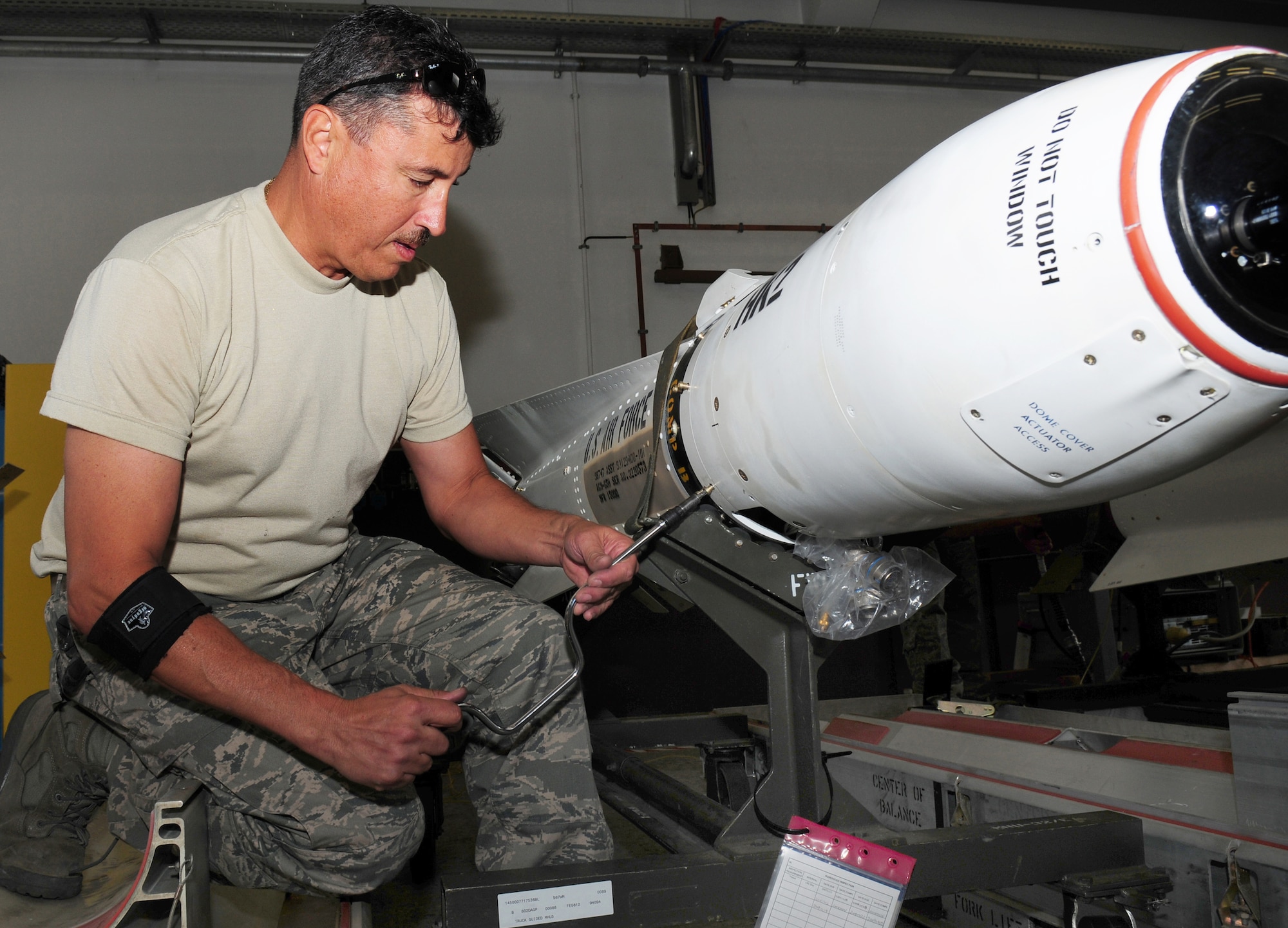 Master Sgt. Eugene Rinaldi removes the guidance control section of an AGM-65 Maverick missile system for upgrades Aug. 11, 2009 at Ramstein Air Base, Germany. Each missile weighs either 466 or 654 pounds, depending on the model. Sergeant Rinaldi is an Air Force Reserve ammunition team member. (U.S. Air Force photo/Staff Sgt. Jocelyn Rich)