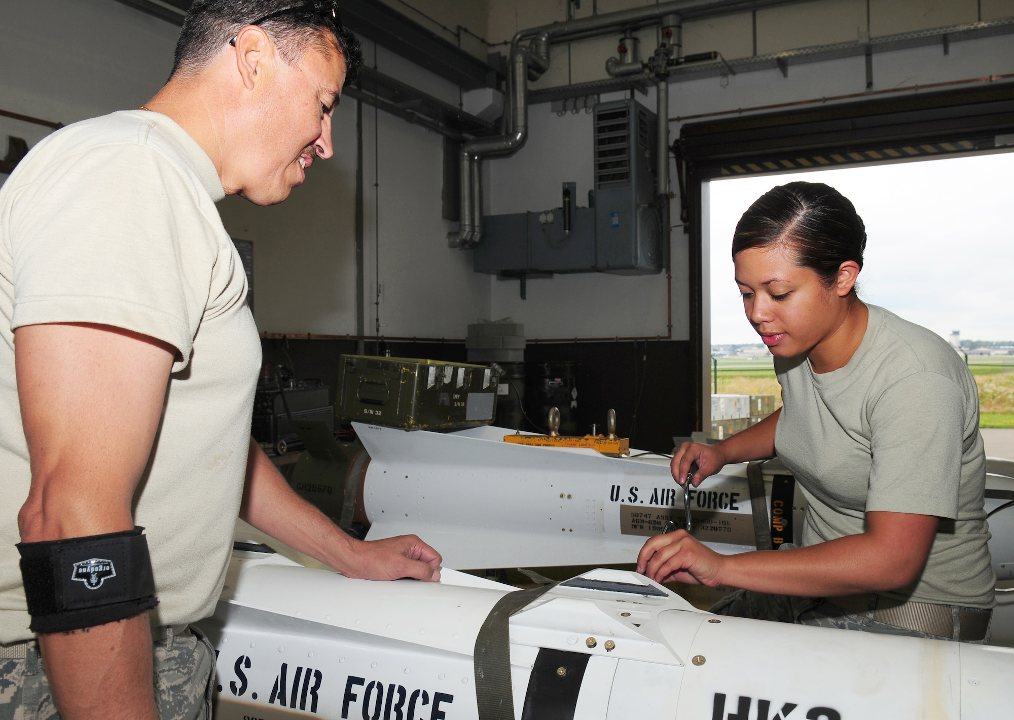 Master Sgt. Eugene Rinaldi (left) and Airman 1st Class Ritchlyn Fryman remove the guidance control section of an AGM-65 Maverick missile system for upgrades Aug. 11, 2009 at Ramstein Air Base, Germany. More than 70 missiles were enhanced with a new software circuit card which allows for more accuracy and adds an abort code for pilots. Sergeant Rinaldi is an Air Force Reserve ammunition team member. Airman Fryman is an 86th Munitions Squadron precision guided munitions crew member. (U.S. Air Force photo/Staff Sgt. Jocelyn Rich)  
