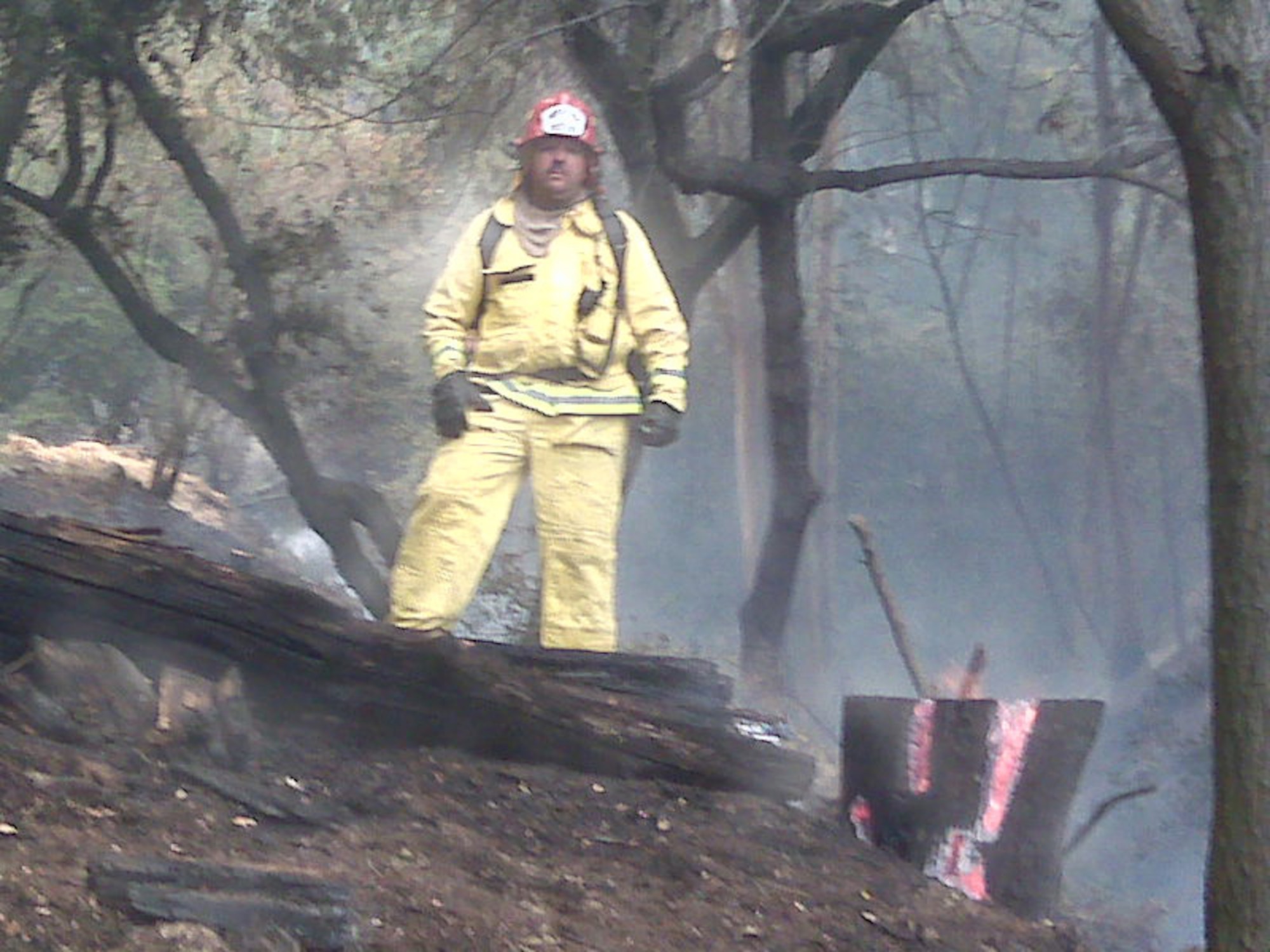 Fire captain Frank Hanson of the March Air Reserve Base (Calif.) firehouse stands in front of a house that his strike team was able to save. The base
firefighters received a request for assistance from the local community Aug. 29, 2009, to help battle the massive Station Fire north of Los Angeles.
(Courtesy photo)
