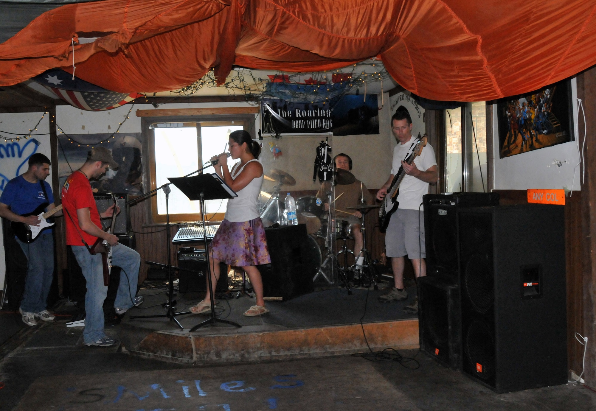 Capt. Brad "Emcon" Brizek takes lead as he and Capt. Alex "Tuna" Turner lay down the chords; Capt. Kevin "Bama" Sweeney keeps the baseline beat on the drums; 1st Lt. Kristine "Sparkie" Knieff belts out a tune, and Lt. Col. Steve "Dallas" Horton blends with the bass during practice here Aug. 9. The captains are pilots with the 35th Fighter Squadron; the colonel is the 35th FS director of operations; and the lieutenant is an executive officer with the 8th Maintenance Group. They are members of Steal Wool.  