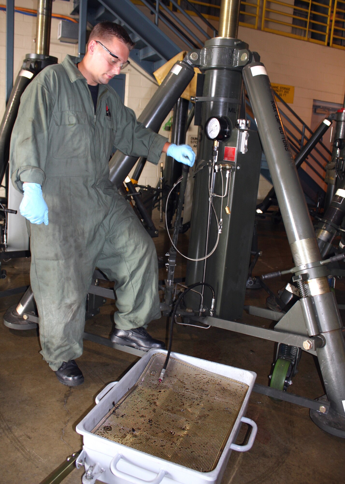 WRIGHT-PATTERSON AIR FORCE BASE, Ohio – Staff Sgt. Joe Edwards, 445th Maintenance Squadron aerospace ground equipment mechanic, drains hydraulic fluid from a 60 ton aircraft jack. Sergeant Edwards identified a cracked weld on the hydraulic tank, which will be repaired here on base. (U. S. Air Force photo/Staff Sgt. Ken LaRock)
