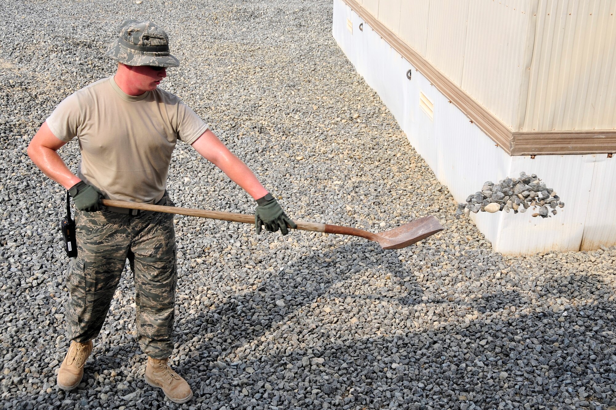 SOUTHWEST ASIA -Senior Airman Grant Coultas, 380th Expeditionary Civil Engineer Squadron, uses a shovel to spread gravel Sept. 03, 2009. Airman Coultas is deployed from Little Rock Air Force Base, Ark., and grew up in Bellevue, Neb. (U.S. Air Force photo/Tech. Sgt. Charles Larkin Sr)