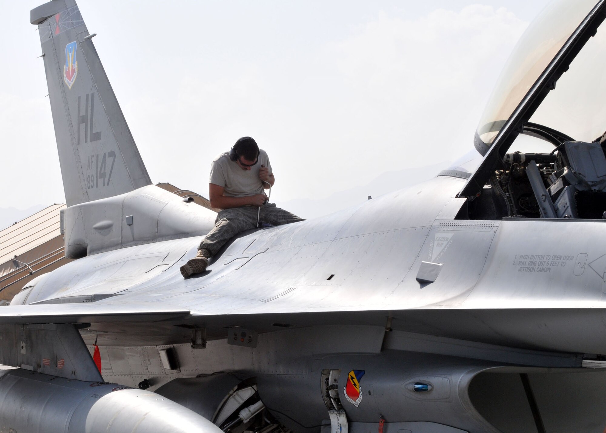 BAGRAM AIRFIELD, Afghanistan -- Airman 1st Class Jeremy Fath, deployed from Hill Air Force Base, Utah, secures a panel on the F-16 after checking the aircraft for cracks, broken pieces or anything out of the ordinary here, Aug. 30, 2009.  Airman Fath is a crew chief from the 455th Expeditionary Aircraft Maintenance Squadron, and hails from Des Moines, Iowa.   The F-16 Fighting Falcon is highly maneuverable aircraft that plays a vital role in supporting Operation Enduring Freedom.  (U.S. Air Force photo/Senior Airman Felicia Juenke)