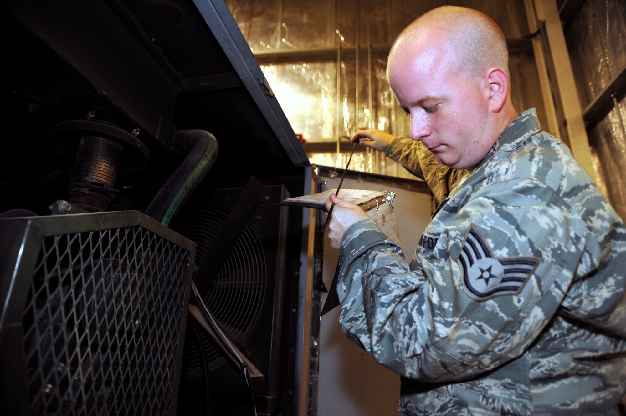SOUTHWEST ASIA -Staff Sgt. James Johnson, 380th Expeditionary Maintenance Squadron, aircraft ground equipment, checks the oil level on an air conditioning unit Sept. 2, 2009. Airman Villarreal is deployed from Dover Air Force Base, Del. (U.S. Air Force photo/Tech. Sgt. Charles Larkin Sr)