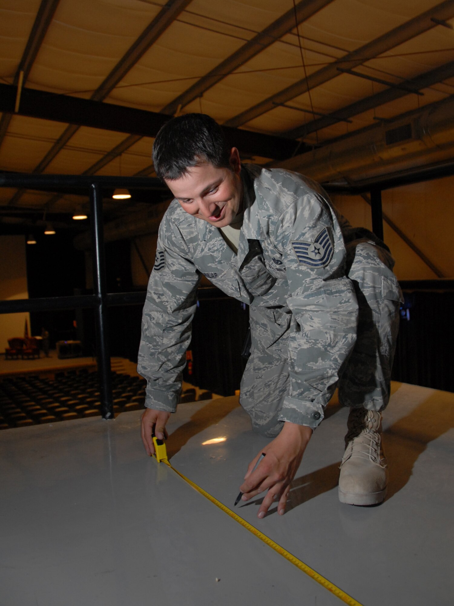 Tech. Sgt. Philip Dunlap, 379th Expeditionary Civil Engineer Squadron zone structures NCOIC, measures floor space for the upcoming theater upgrade project, here, Sept. 3. Sergeant Dunlap is deployed from Kadena Air Base, Japan in support of Operations Iraqi and Enduring Freedom.  (U.S. Air Force Photo/Tech. Sgt. Jason W. Edwards)