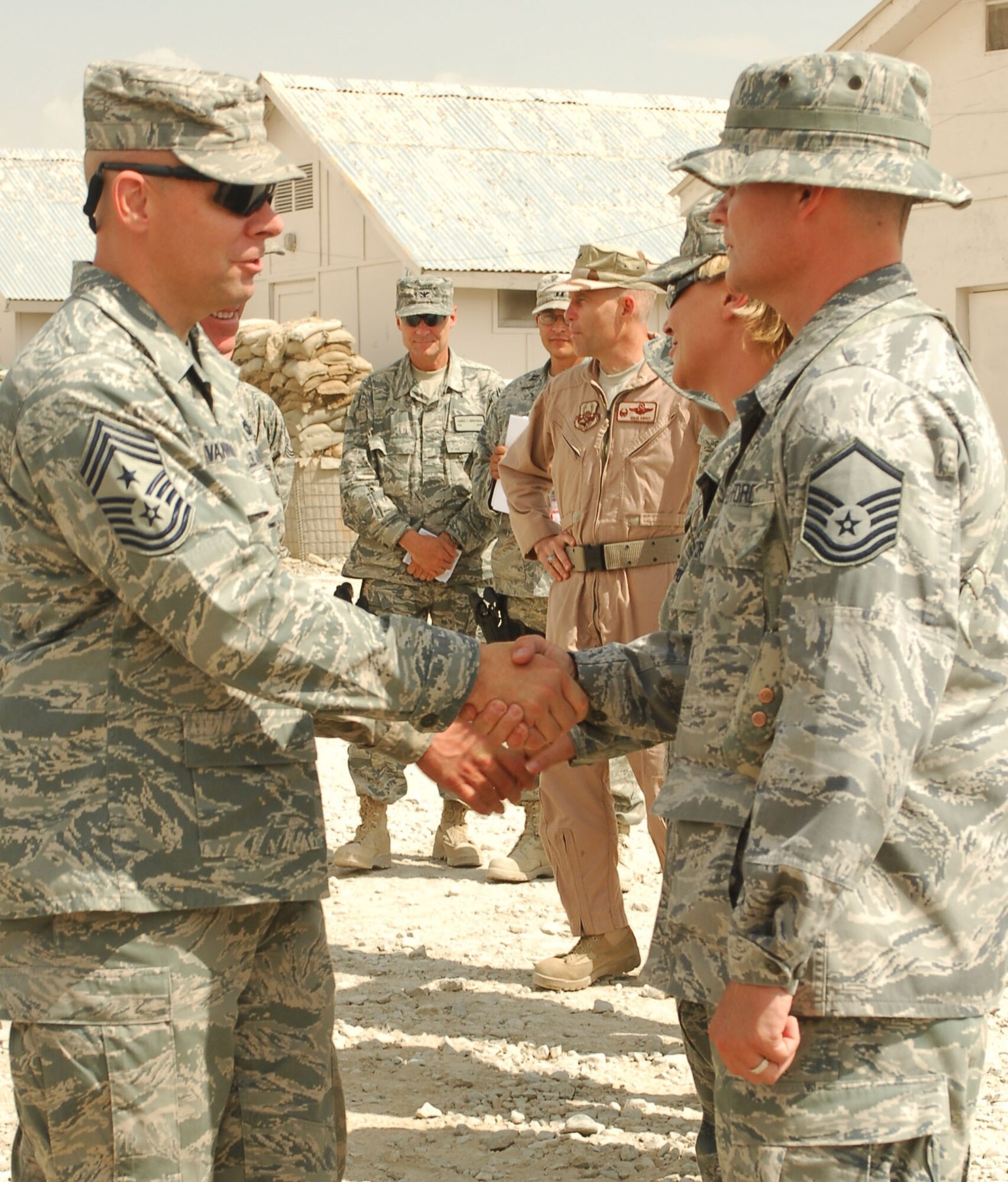 FORWARD OPERATING BASE LIGHTNING - Chief MSgt. Dennis Vannorsdall, 455th Air Expeditionary Wing command chief, congratulates Master Sgt. Gary Walters, Medical Embedded Training Team, for being an FOB Superior Performer, Aug. 30, 2009.   The Airmen are assigned to FOB Lightning as Joint Expeditionary Tasked Airmen who work day to day for U.S. Army commanders while they're also administratively assigned to U.S. Air Force commanders under the 755th Air Expeditionary Group at Bagram Airfield, Afghanistan.  The JET Airmen are part of the Embedded Training Team, which mentors Afghan National Army Forces in many skills to include medical and public affairs. (U.S. Air Force photo/Capt. David Faggard)