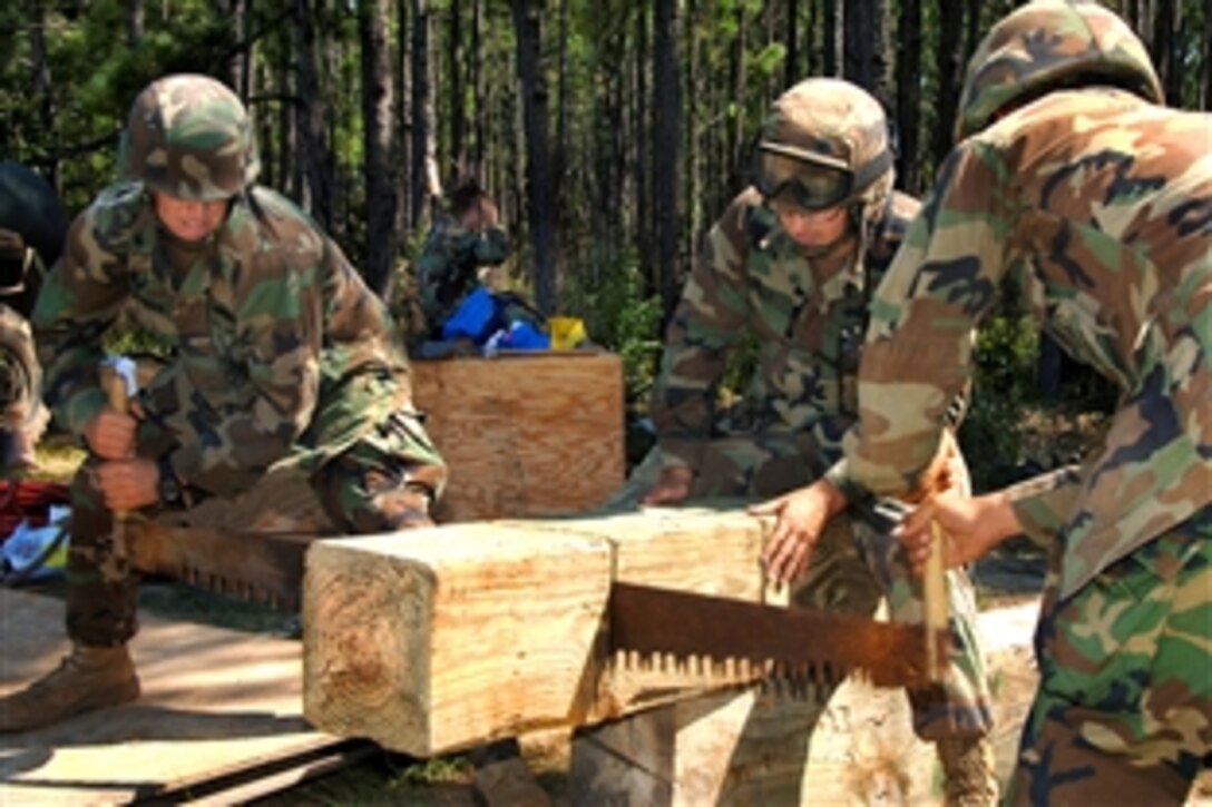 U.S. Navy sailors with Naval Mobile Construction Battalion 133 cut wood to build a timber tower during the unit's field training exercise on Camp Shelby, Miss., Aug. 24, 2009.
