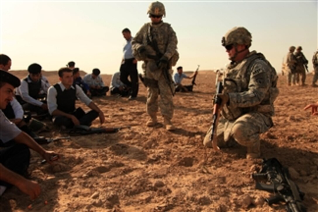 U.S. Army 1st Lt. Carl Yeaney with the 218th Military Police Company out of Fort Campbell, Ky., instructs Iraqi police officers on how to fire weapons from the kneeling position during AK-47 assault rifle training in Mammah, Iraq, on Aug. 30, 2009.  