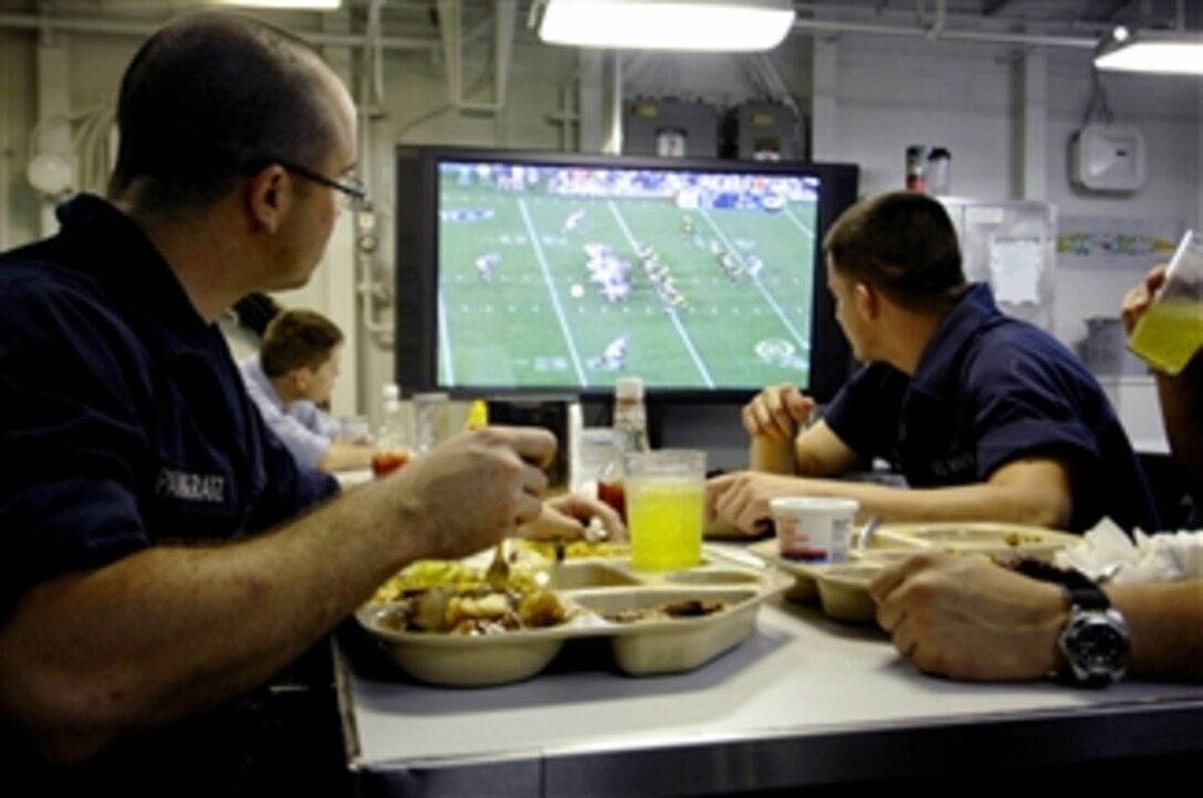 U.S. Navy sailors aboard the aircraft carrier USS Harry S. Truman (CVN 75) underway in the Atlantic Ocean watch a preseason football game while eating in the mess on Aug. 25, 2009.  The NFL Network was recently added to the ship's cable television lineup.  