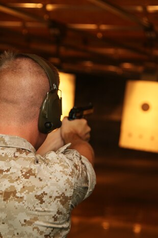 A Marine sites in on his target during the rapid fire portion of the shooting competition held in the indoor small arms range here Sept. 4. The shooting competition was the second of four events held to win one of five seats aboard a C-12 for a chance to go on a South Pacific island hopping adventure. Cpl. Justin Hudnall, a Provost Marshall’s Office military police officer, won the competition leaving only two seats up for grabs.