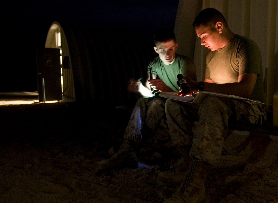 Lance Cpl. Eric Sanchez teaches Lance Cpl. Alex Messick the language of Pashtu at night outside of their living area at Marine Corps Air Ground Combat Center Twentynine Palms, Calif. Before joining the Marine Corps, Sanchez studied Pashtu and Farsi while attending college. Both Marines are intelligence analysts with 1st Battalion, 3rd Marine Regiment’s intelligence section and are participating in Exercise Mojave Viper pre-deployment training.