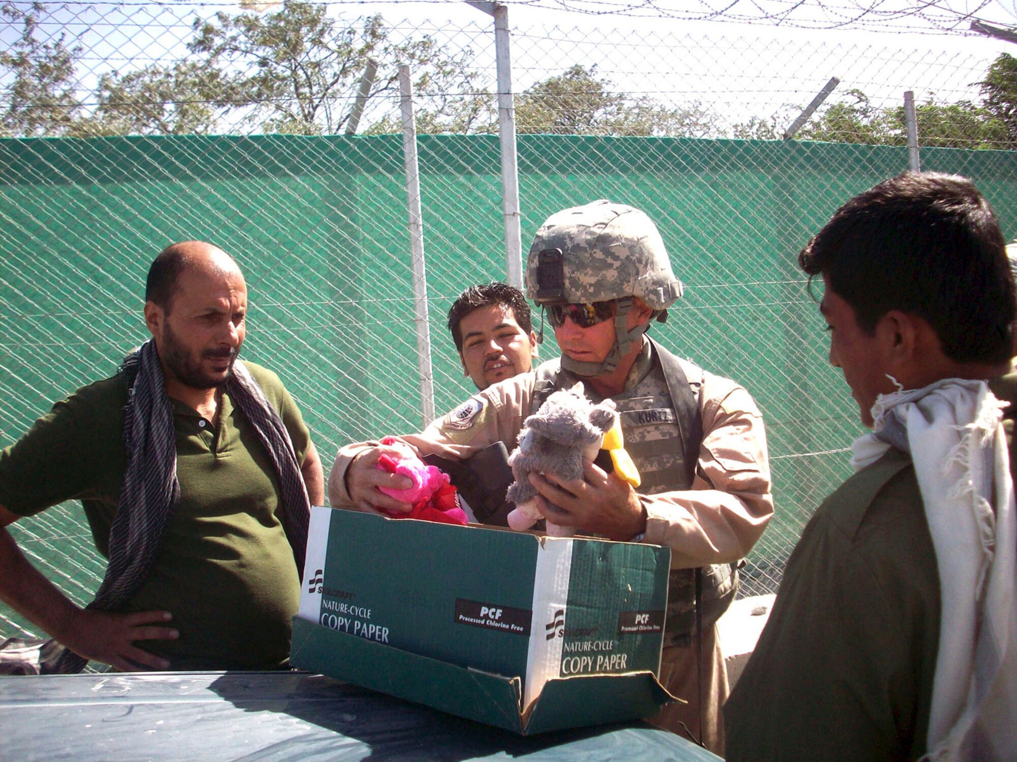 BAGRAM AIRFIELD, Afghanistan - Air Force Master Sgt. Stephen Kurtz hands out toys to local national workers here. Operation Care is an organization at Bagram Airfield, that receives donations of hygiene items, clothing, toys, and comfort items. (Courtesy photo)