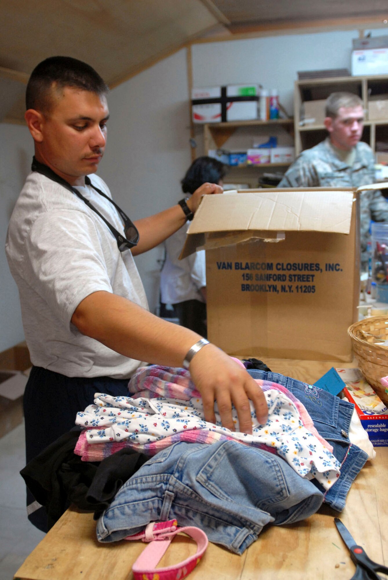 BAGRAM AIRFIELD, Afghanistan - Air Force Capt. Christopher A. Dupuis helps separate and load children’s clothing into boxes while volunteering at Operation Care here recently. Operation Care is an organization on Bagram Airfield that receives donations of hygiene items, clothing, toys and comfort items for the troops and people in remote locations in Afghanistan. (U.S. Army photo/Spc. Opal Hood)

