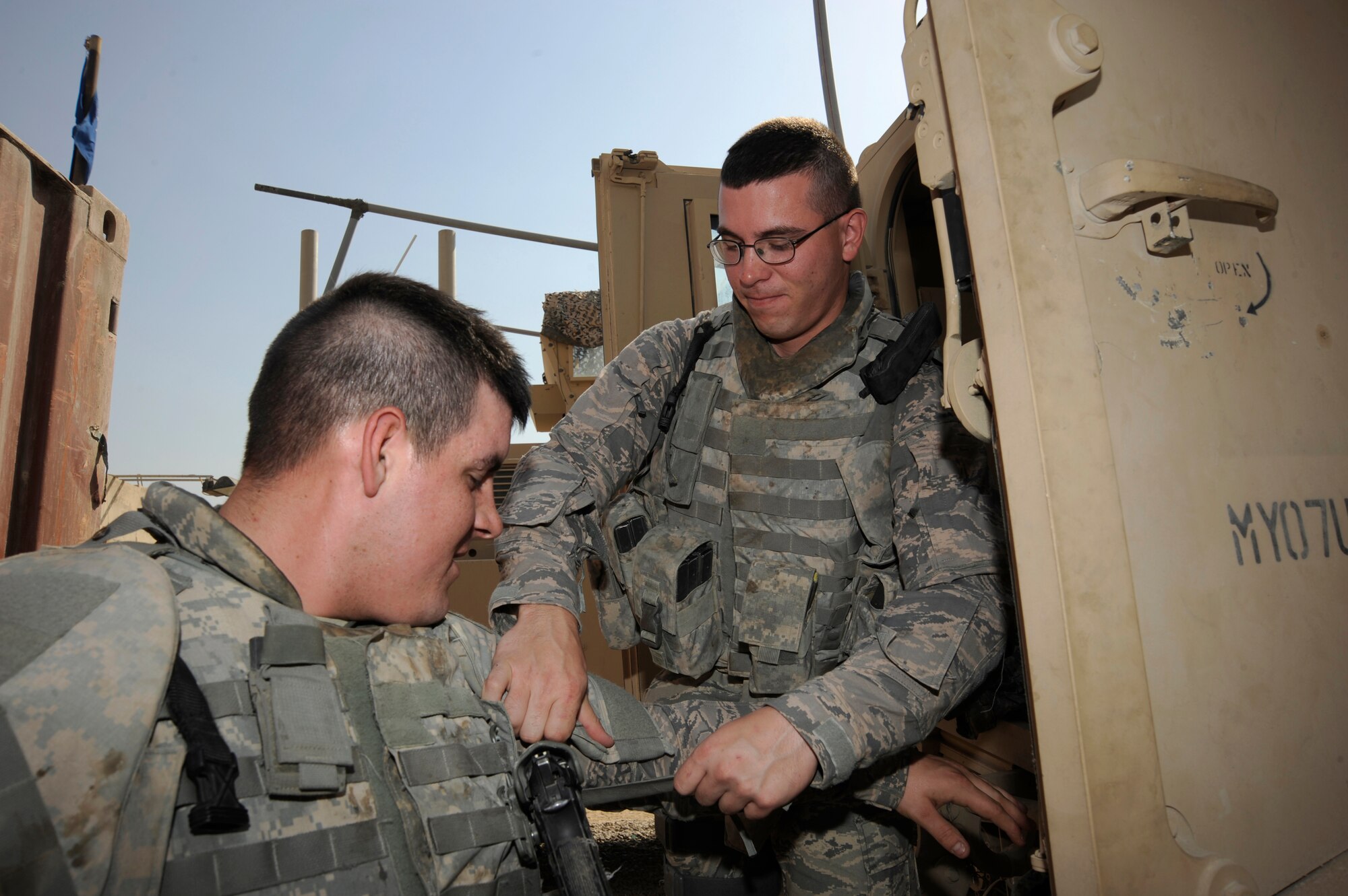 CAMP STRYKER, Iraq -- Air Force Senior Airman Christopher Cable (right) helps Senior Airman Jason Gregory (left), don his individual body armor protection here Aug. 22, 2009. Both Airmen are assigned to the 732nd Expeditionary Security Forces Squadron Detachment 2 Police Transition Team, which performs outside-the-wire missions training Iraqi policemen and conducting intelligence operations to enhance the security of the country. Airman Gregory is deployed from Langley Air Force Base, Va., and is a native of New Caney, Texas, and Airman Cable is deployed from United States Air Force Academy, Col., and is a native of Niagara Falls, N.Y. (U.S. Air Force photo/Tech. Sgt. Johnny L. Saldivar)   
