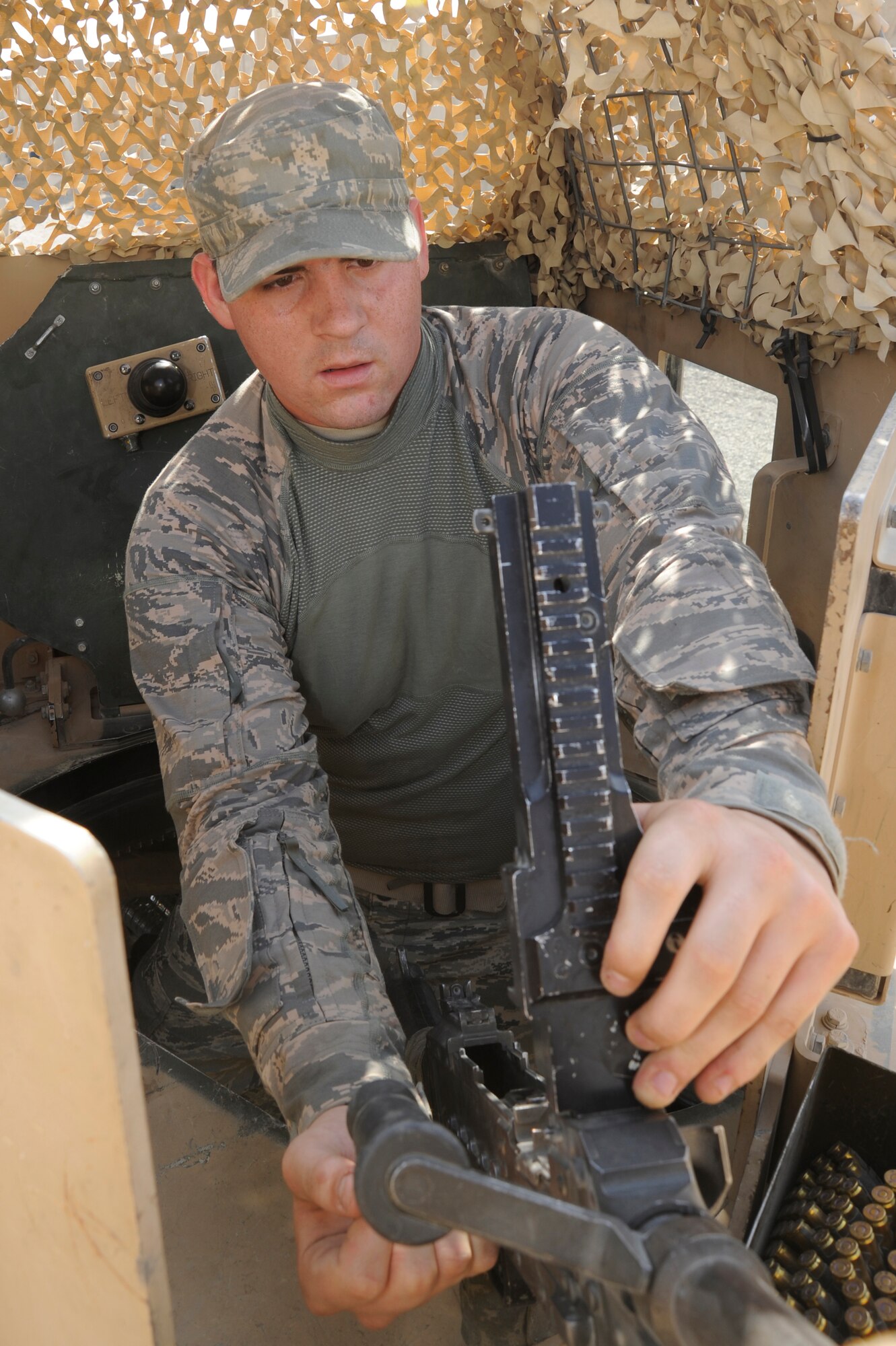 CAMP STRYKER, Iraq -- Air Force Senior Airman Jason Gregory, 732nd Expeditionary Security Forces Squadron Detachment 2 Police Transition Team gunner, performs maintenance checks on a .50 caliber machine gun mounted in a Humvee gunner turret here Aug. 22, 2009. The checks ensure his weapon is ready to provide support to the team while performing outside-the-wire missions. The 732nd ESFS trains Iraqi policemen and conducts intelligence operations to enhance the security of the country. Airman Gregory is deployed from Langley Air Force Base, Va., and is a native of New Caney, Texas.  (U.S. Air Force photo/Tech. Sgt. Johnny L. Saldivar)   