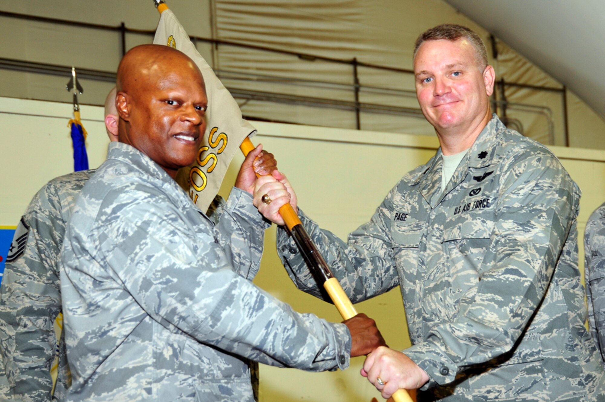 Col. Soren Jones, 380th Expeditionary Operations Group commander, passes the guidon to Lt. Col. Daryl Page, 380th Expeditionary Operations Support Squadron commander, during the EOSS Change of Command Ceremony Sept. 1. (U.S. Air Force/Tech. Sgt. Charles Larkin)
