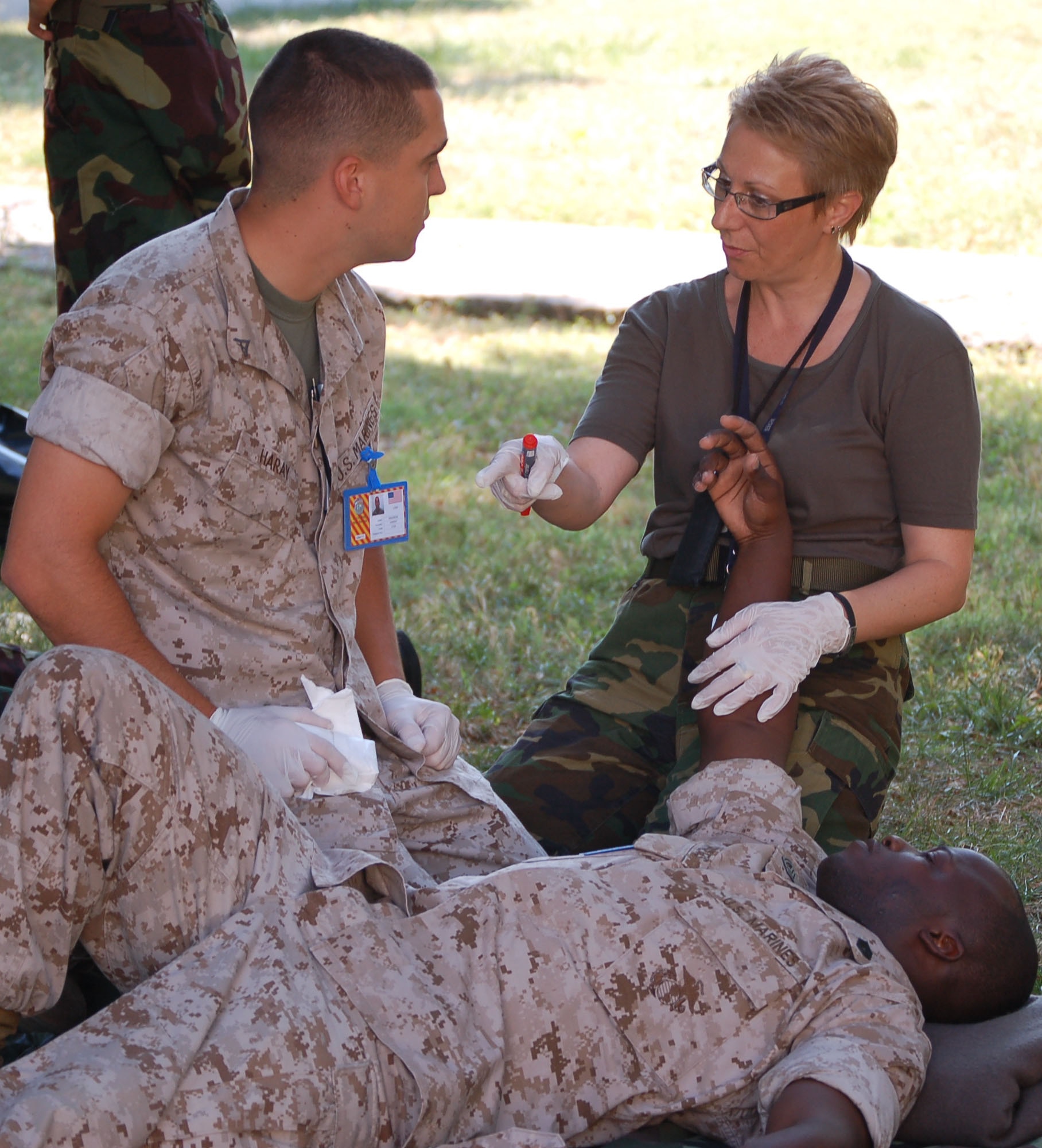 NIS, Serbia – Dona Poptrandova, Macedonian senior medical nurse and combat lifesaver course instructor supervisor, discusses possible medical scenarios with Lance Cpl. Andrew Haray (left) while Gunnery Sgt. Octavius Shivers plays the role of a wounded Marine Sept. 4 during the military medical training exercise in Central and Eastern Europe, or MEDCEUR 2009, combat lifesaver course. (U.S. Air Force photo/Senior Airman Kali L. Gradishar)